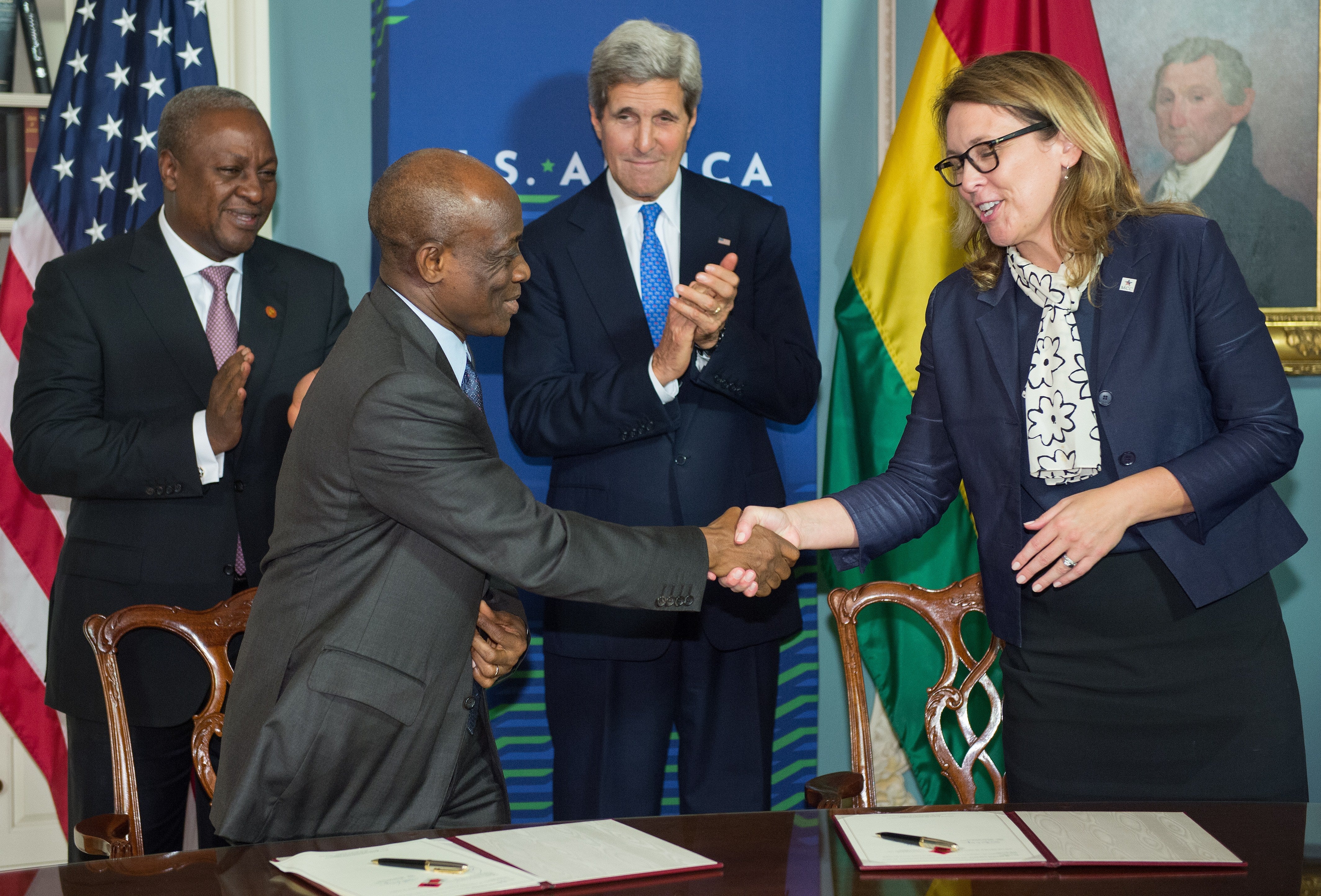 Dana Hyde, CEO of the Millennium Challenge Corporation, shakes hands with Ghana finance minister Seth Terkper as Ghana President John Dramani Mahama, left, and US Secretary of State John Kerry look on, during the signing the Ghana Compact at the State Department on 6 August 6, 2014