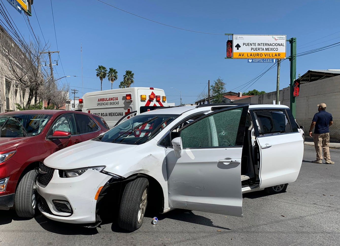 A member of the Mexican security forces stands next to the white minivan belonging to the four kidnapped Americans in Matamoros