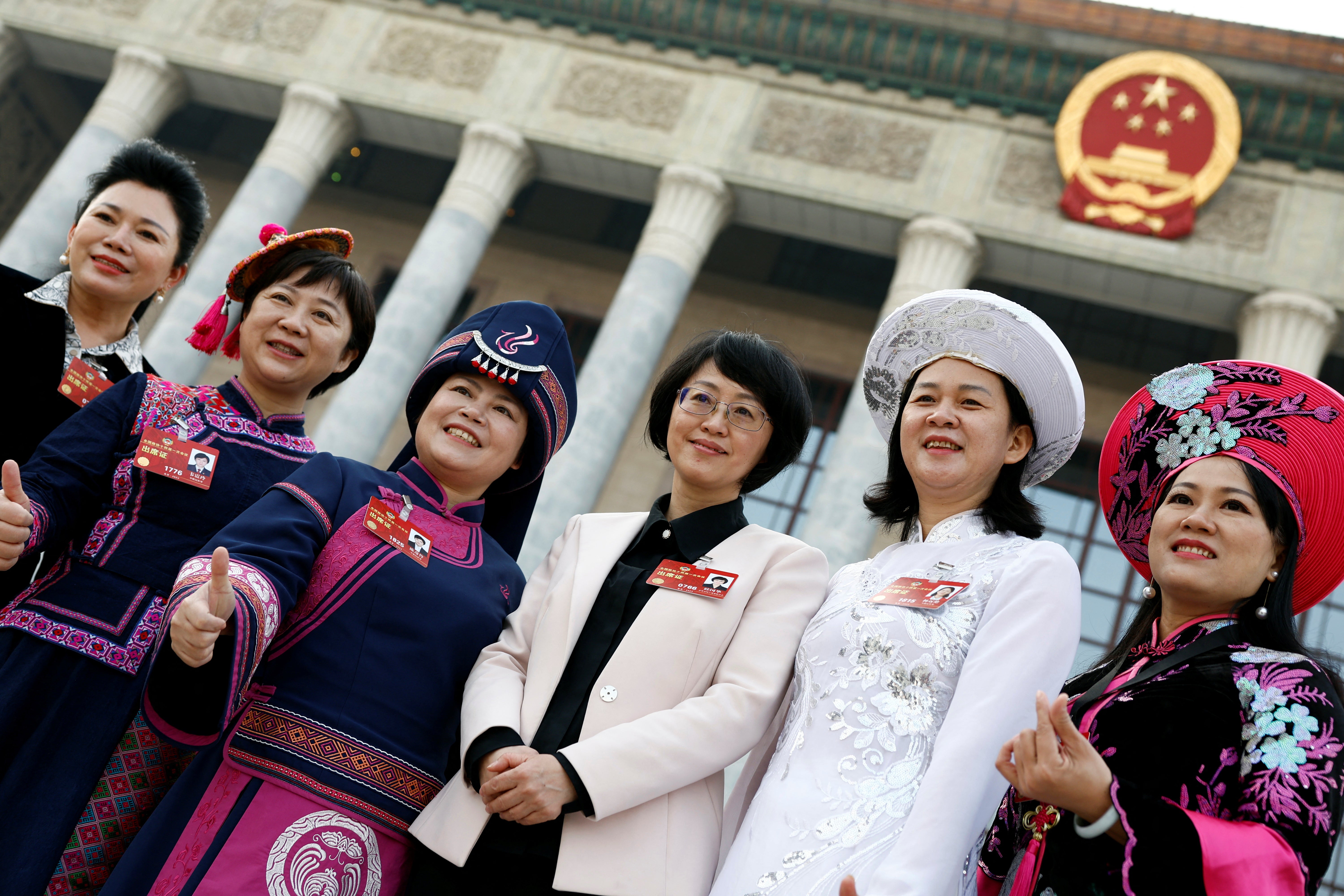 Women delegates pose for pictures outside the Great Hall of the People following the opening session of the Chinese People's Political Consultative Conference (CPPCC) in Beijing