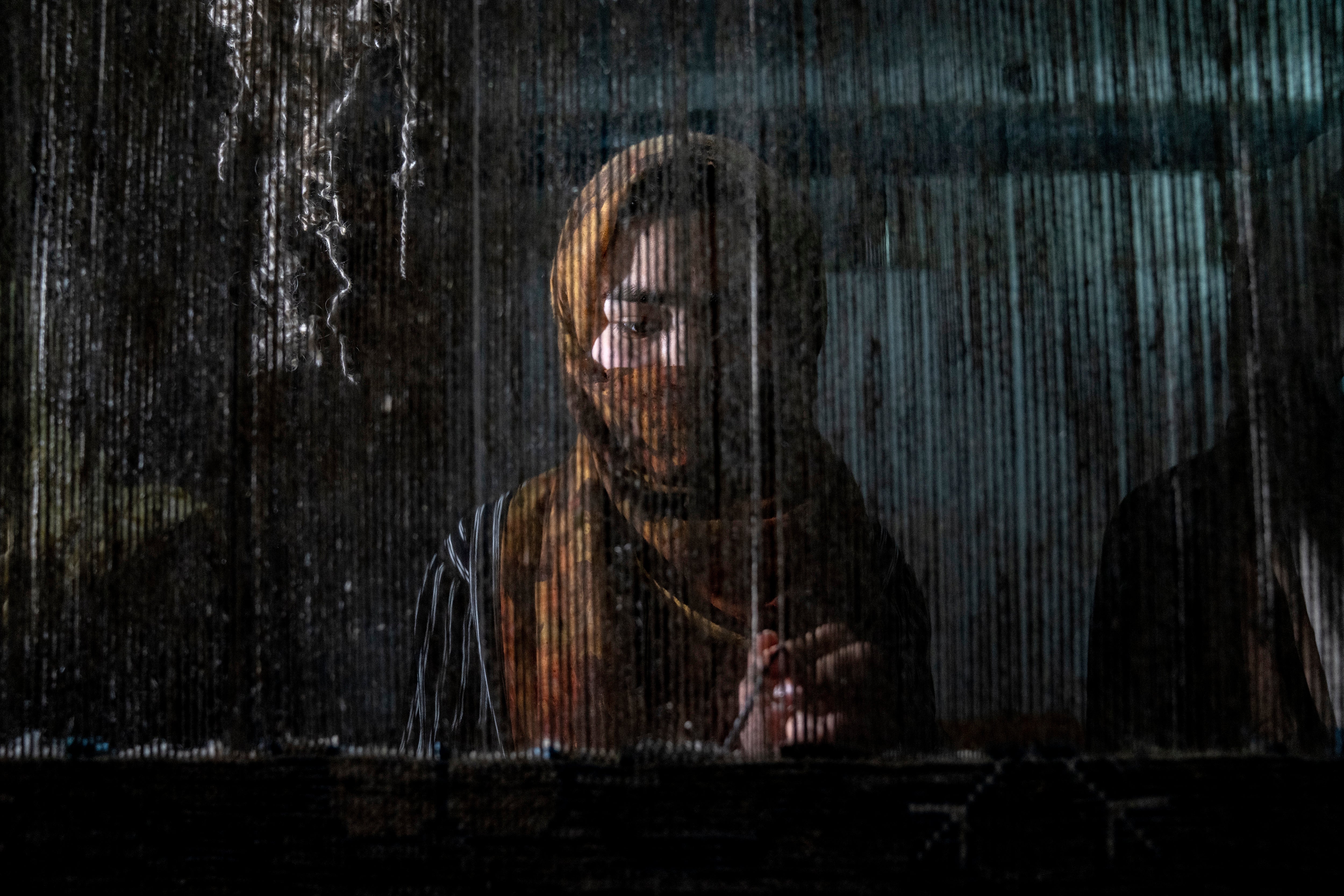 An Afghan woman weaves a carpet at a traditional carpet factory in Kabul, Afghanistan where women have seen their freedom increasingly restricted since Taliban came into power