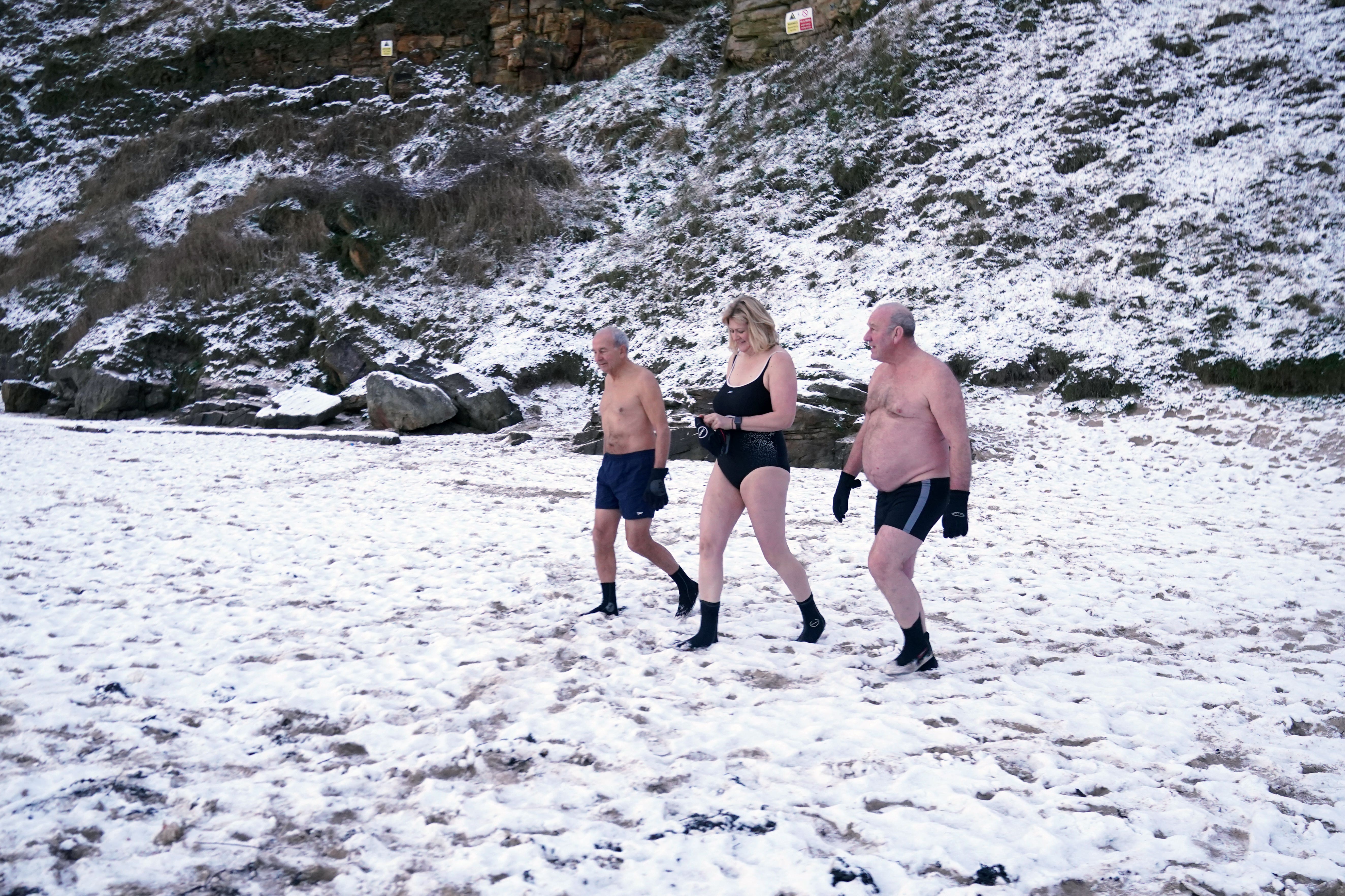 Early morning swimmers brave the cold at King Edward’s Bay, near Tynemouth on the North East coast of England, as parts of the UK wake up to snow and a yellow weather warning (Owen Humphreys/PA)