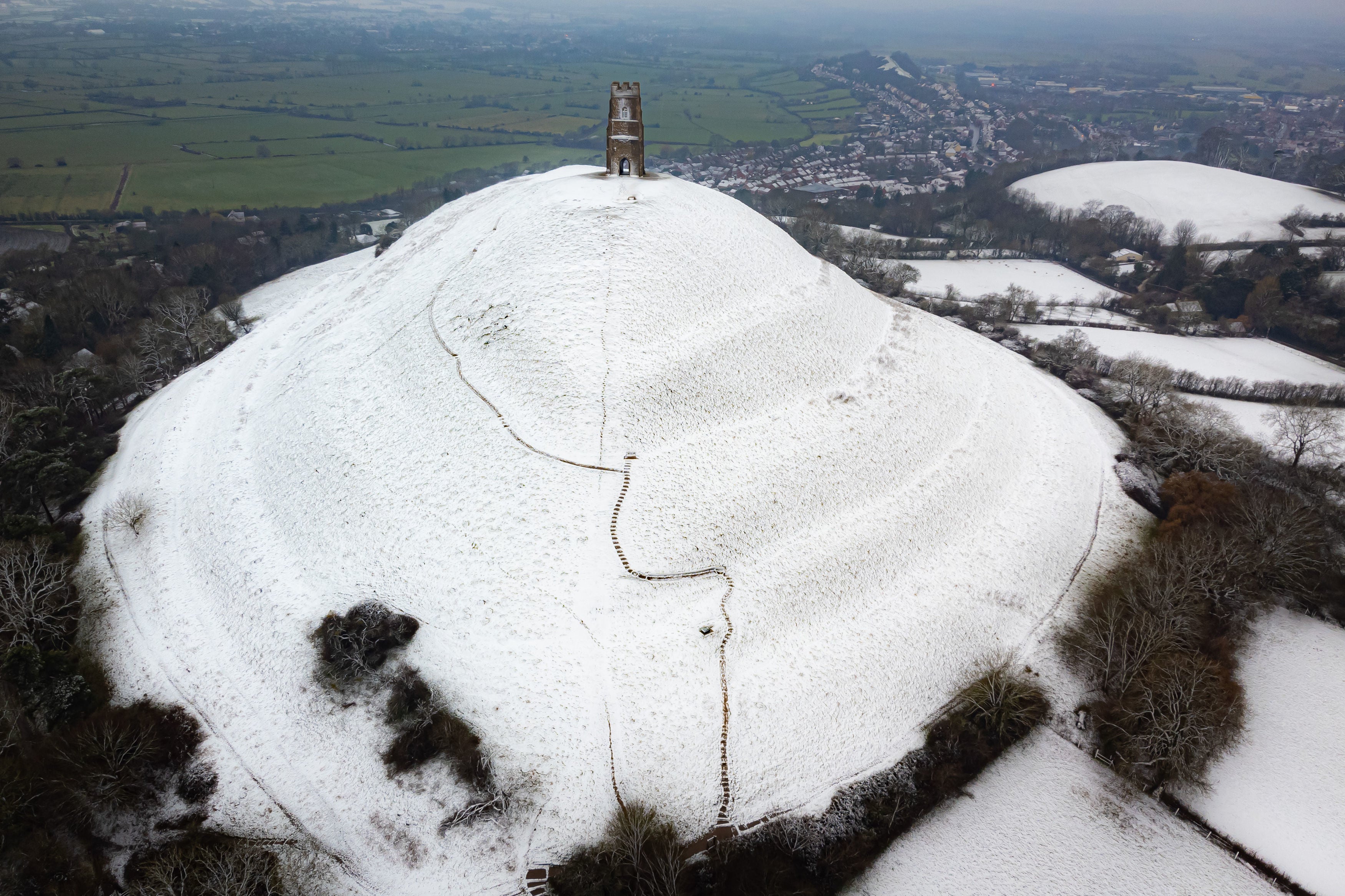 Snow settles on Glastonbury Tor as parts of the UK wake up to snow and a yellow weather warning