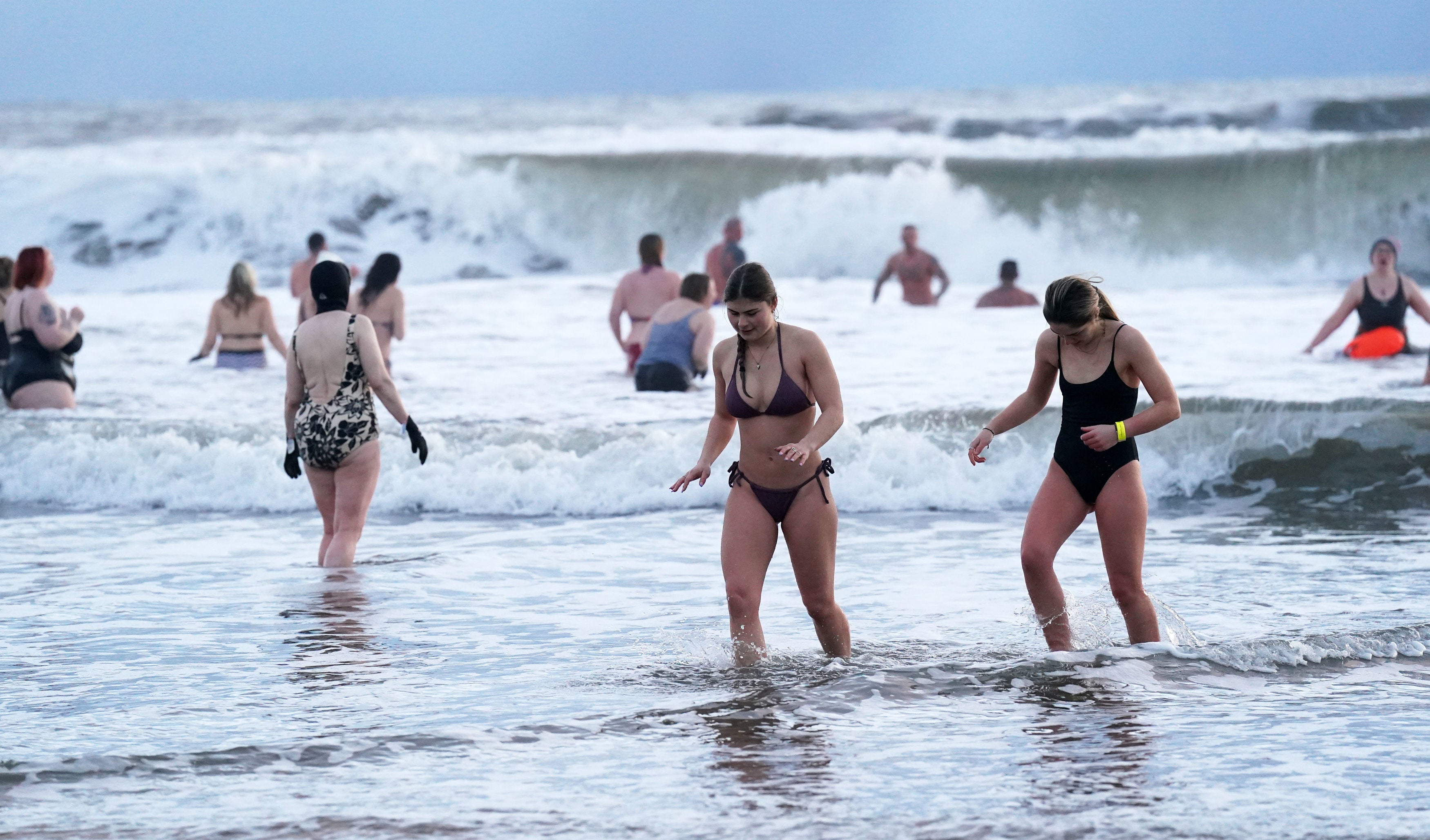 A group of swimmers brave the freezing conditions as they gather to celebrate International Women’s Day at King Edward’s Bay