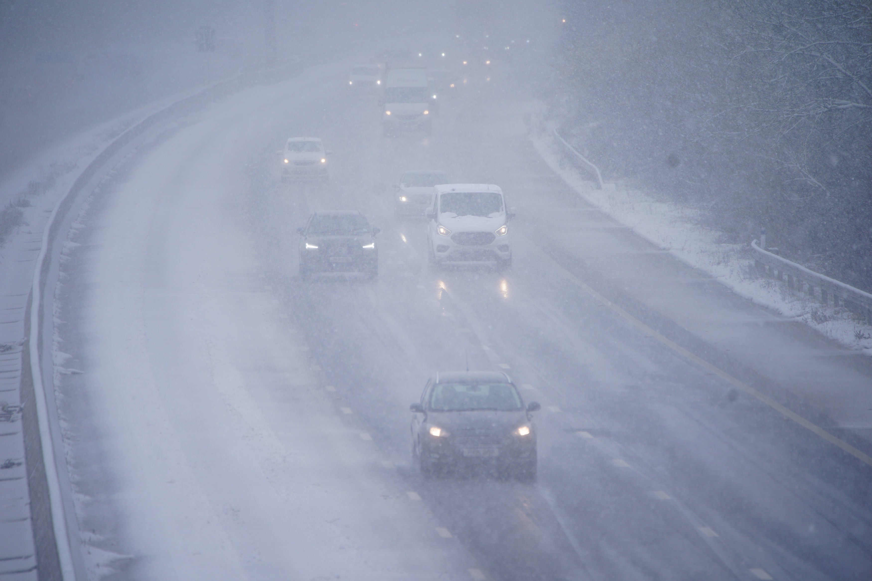 Cars driving through snow on the northbound carriageway of the M5 motorway near Taunton, which has been reduced to two lanes due to snow