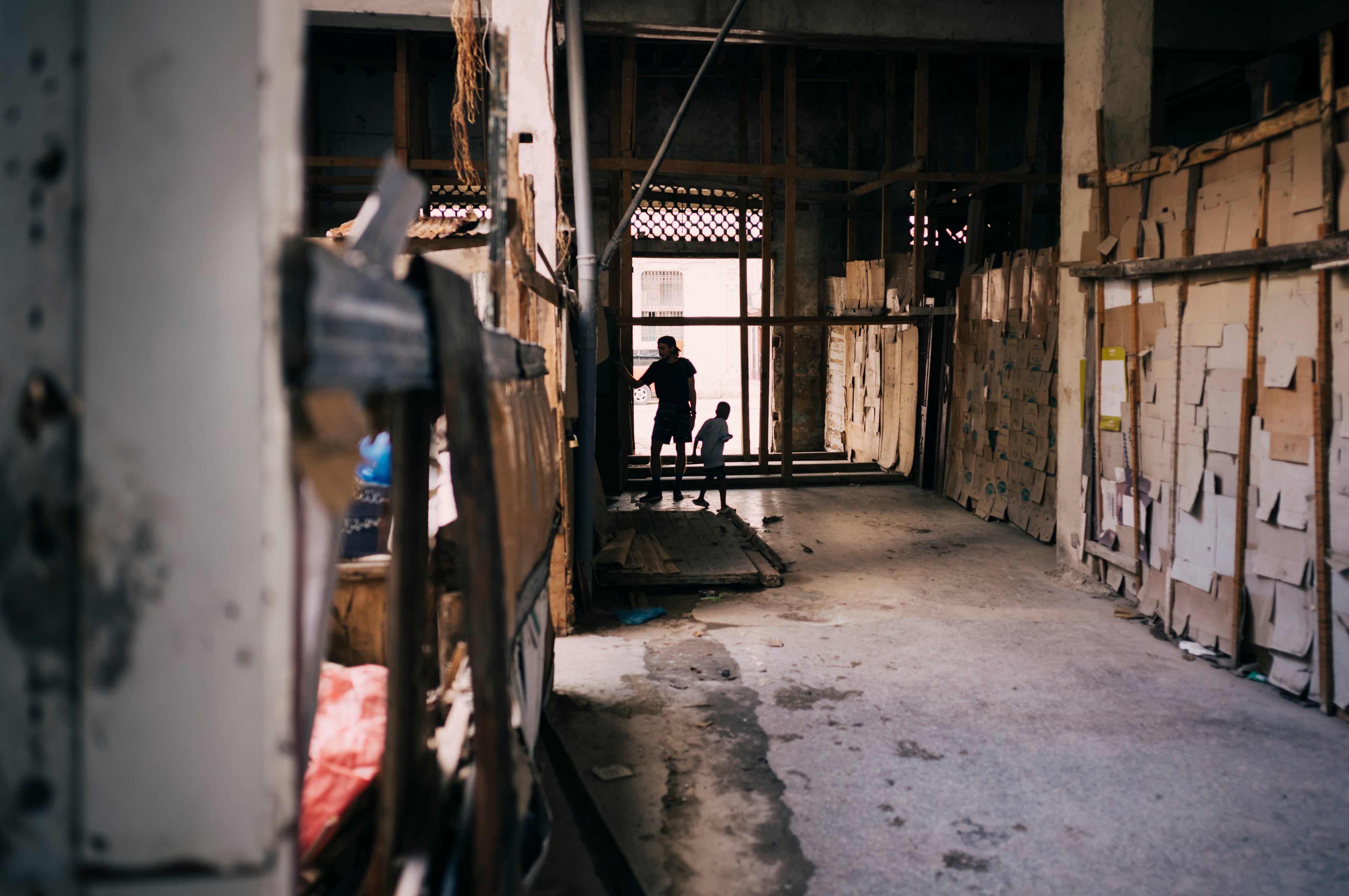 A young Cuban man and child play in the hallway of an abandoned building