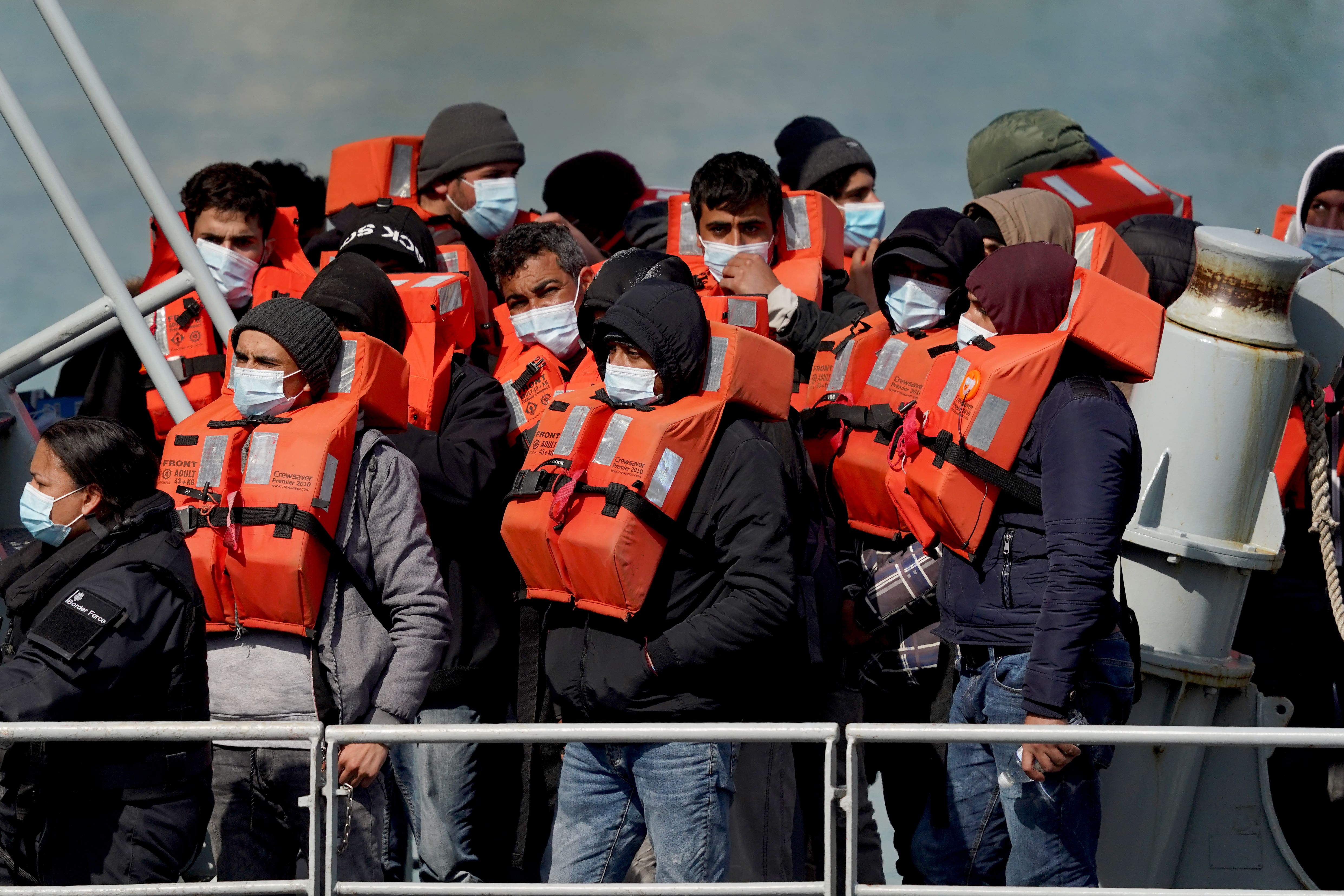 A group of people arriving on small boats brought in to Dover, Kent