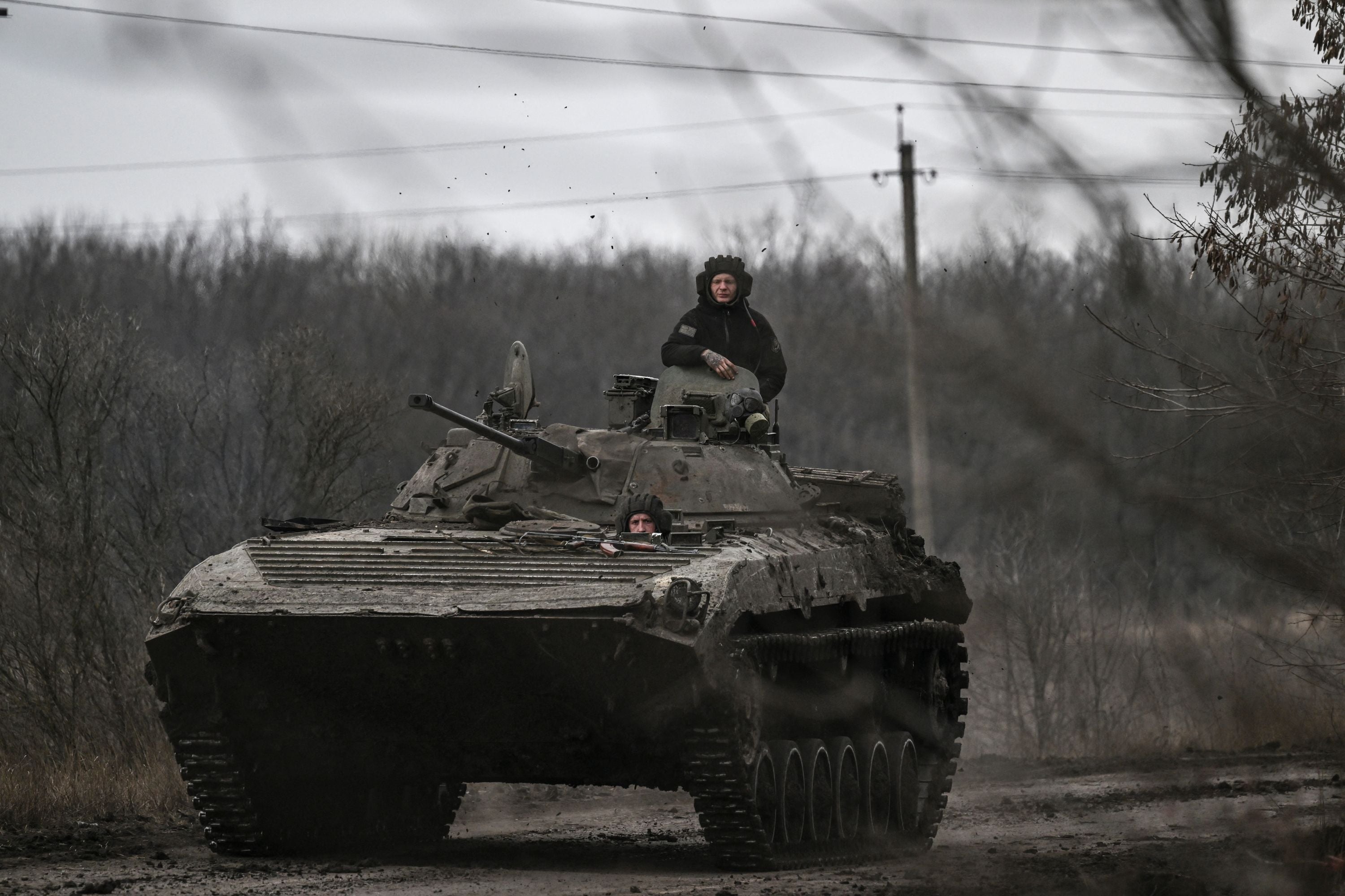 Ukrainian servicemen on a BMP-2 tank drive towards the city of Bakhmut on Saturday