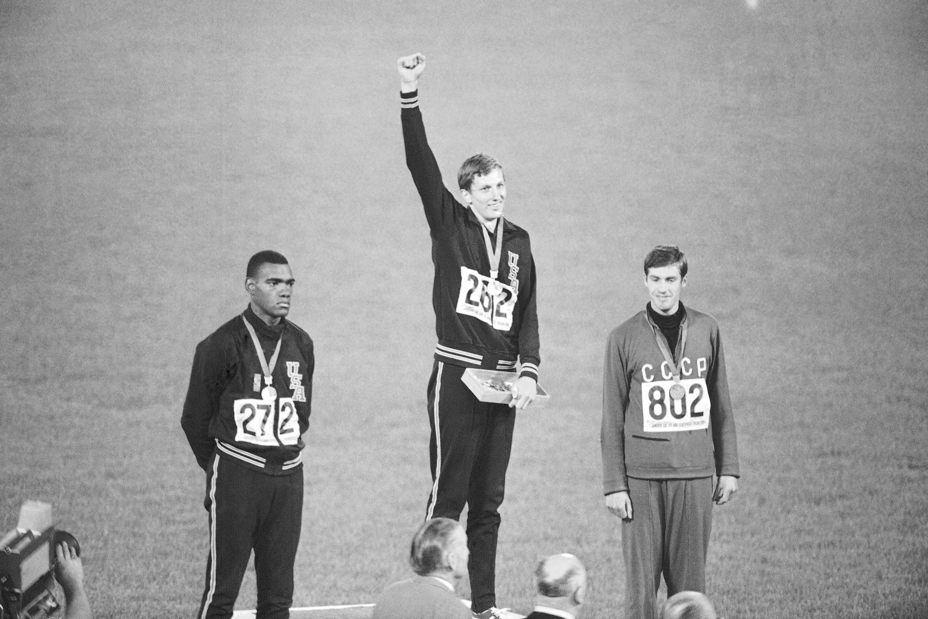 Dick Fosbury raises his arm aloft after winning gold