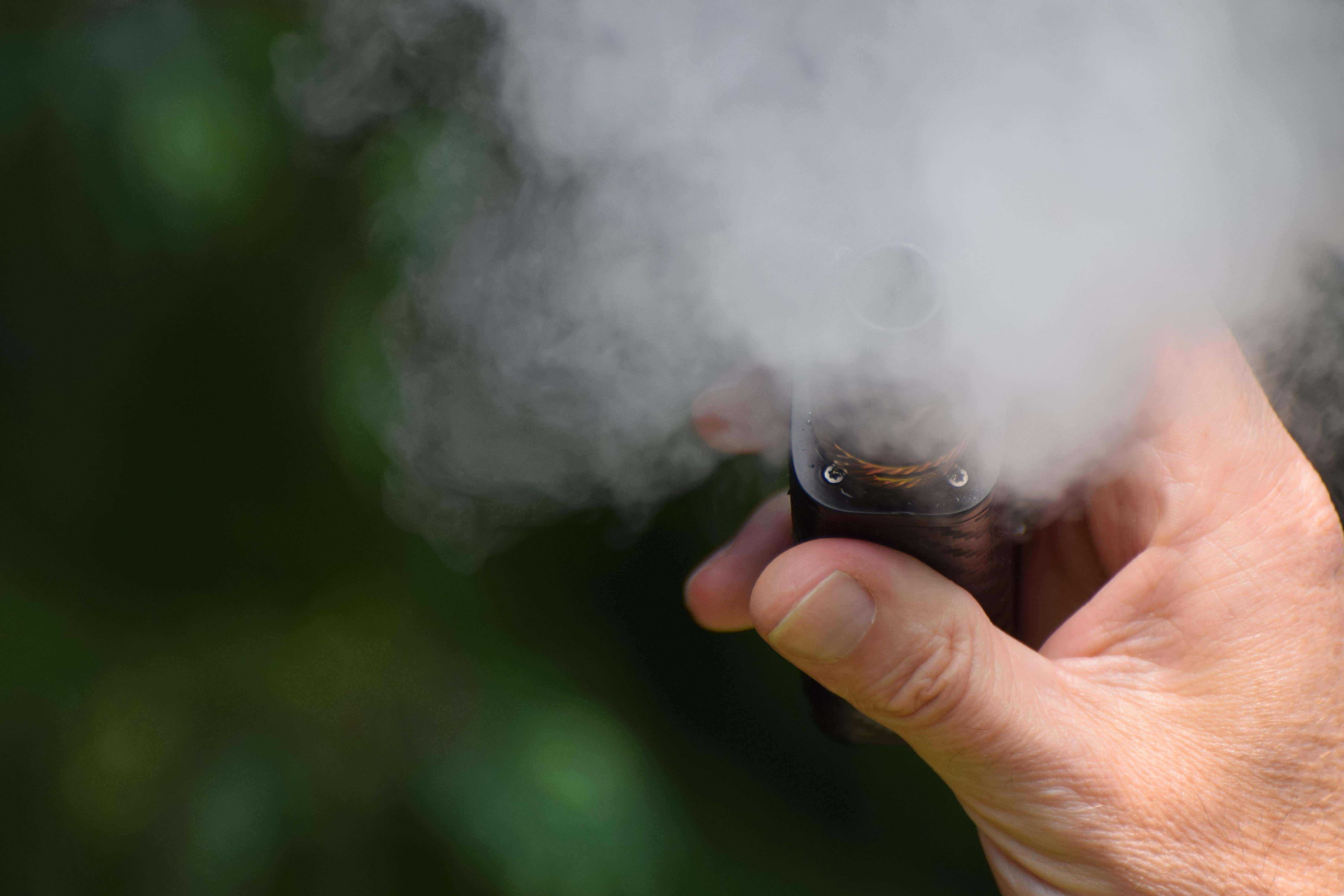 A close up of a hand holding an e-cigarette. New research suggests teenagers are less likely to vape if the packaging is non-branded. PA.