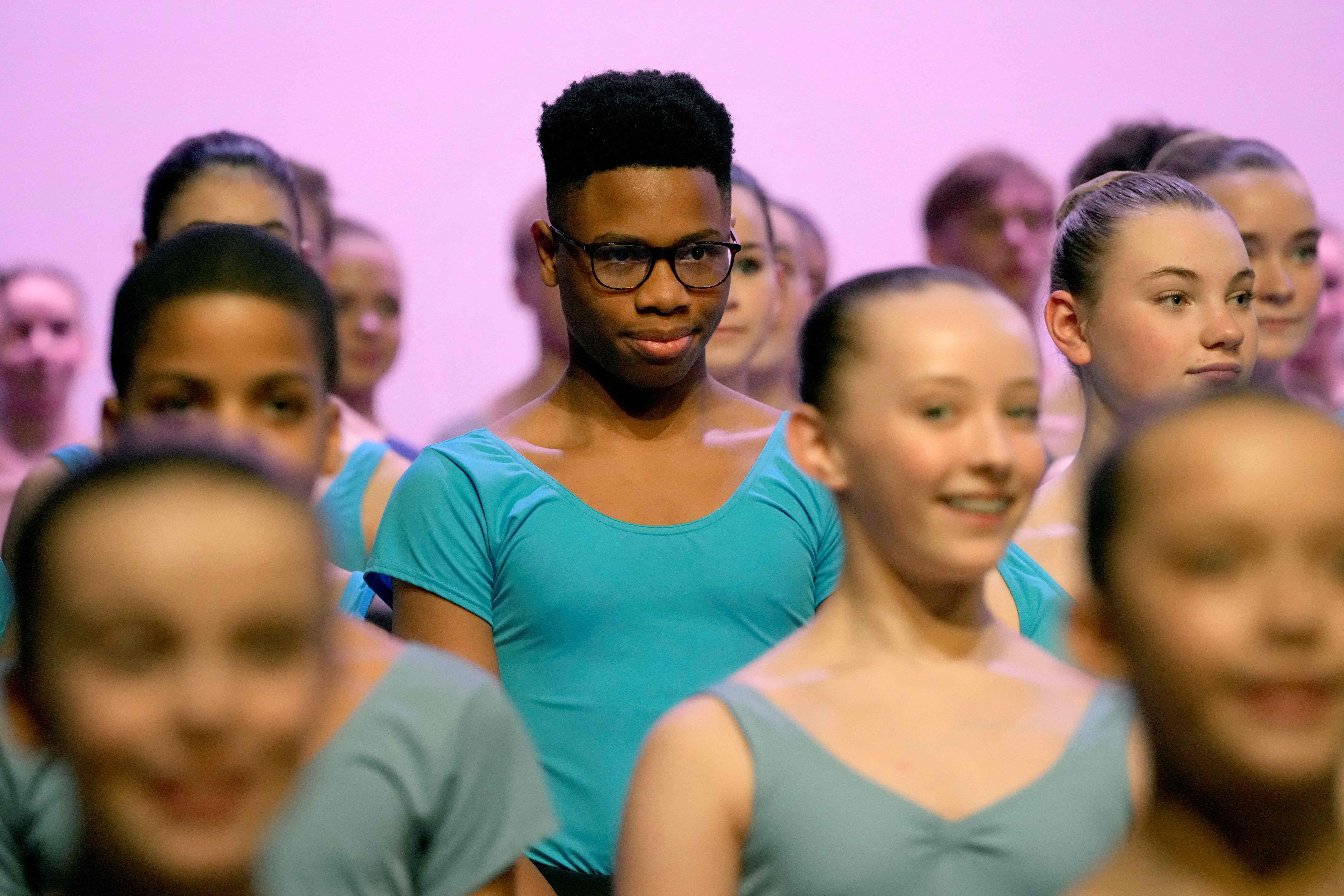 Nigerian dancer Anthony Madu stands with ballet pupils as they give a performance for Camilla, Queen Consort during her visit