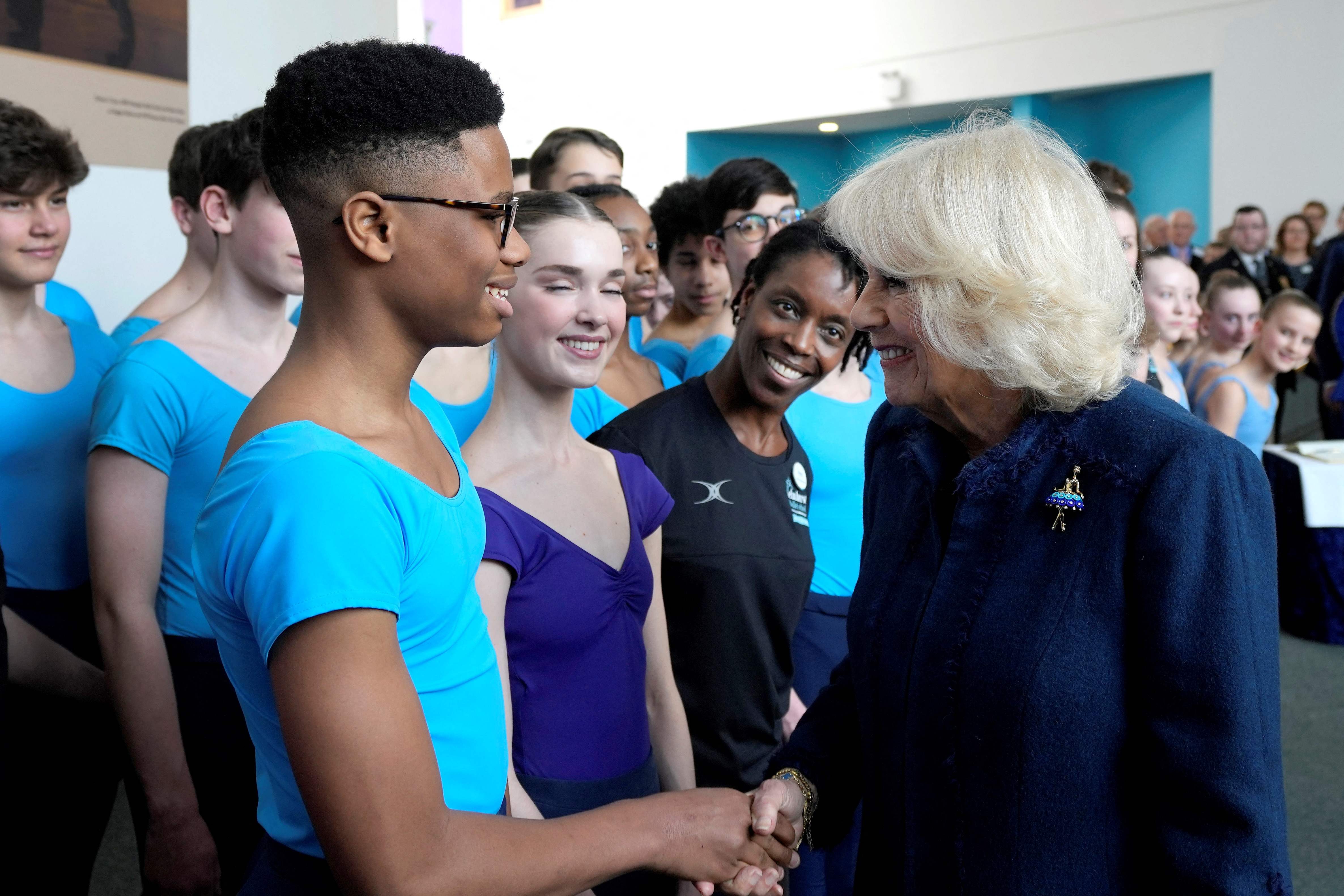 Camilla, Queen Consort (R) meets Nigerian dancer Anthony Madu, who won a scholarship after a video of him dancing in Lagos went viral, during her visit to the Elmhurst Ballet School