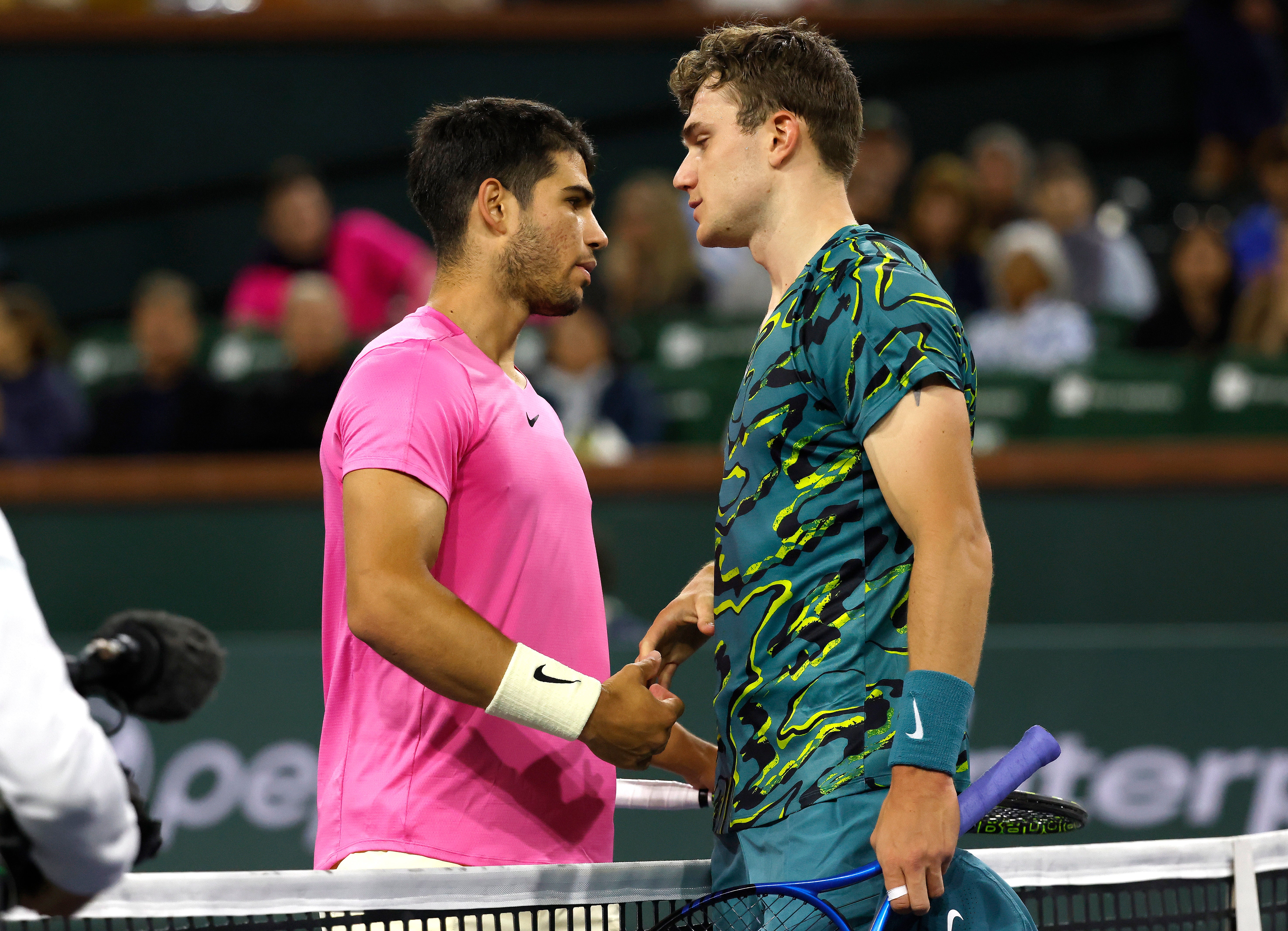 Jack Draper, right, is consoled by Carlos Alcaraz at the net