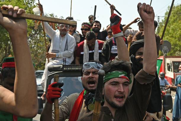 Supporters of former Pakistan’s prime minister Imran Khan shout slogans as they march towards his residence in Lahore on 16 March 2023