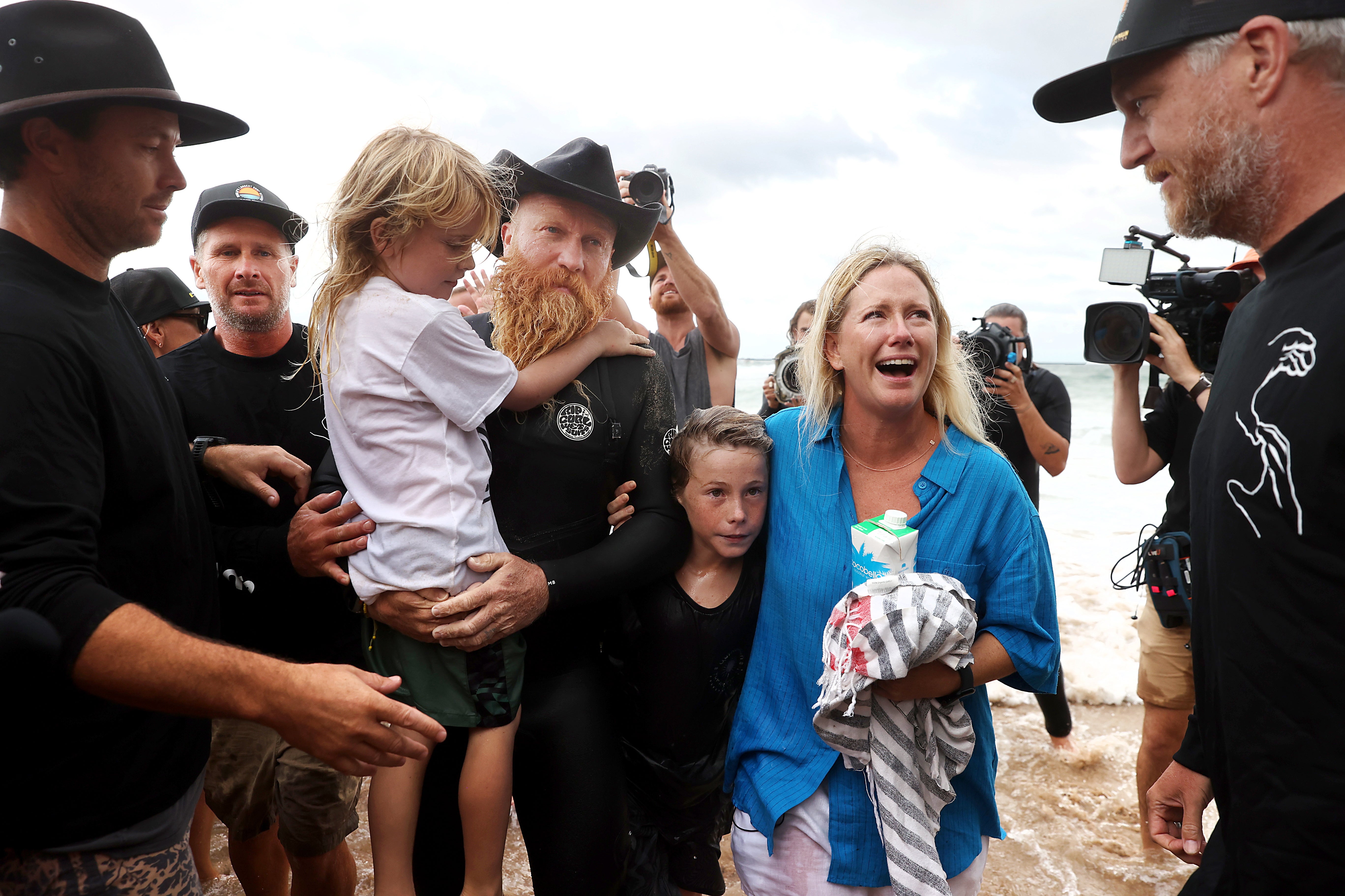 Blake Johnston is greeted by his wife Lauren and children as well as his support team after achieving a new world record for the longest surf session of 500 waves in over 30 hours, at The Alley in Cronulla, in Sydney, Australia, 17 March 2023