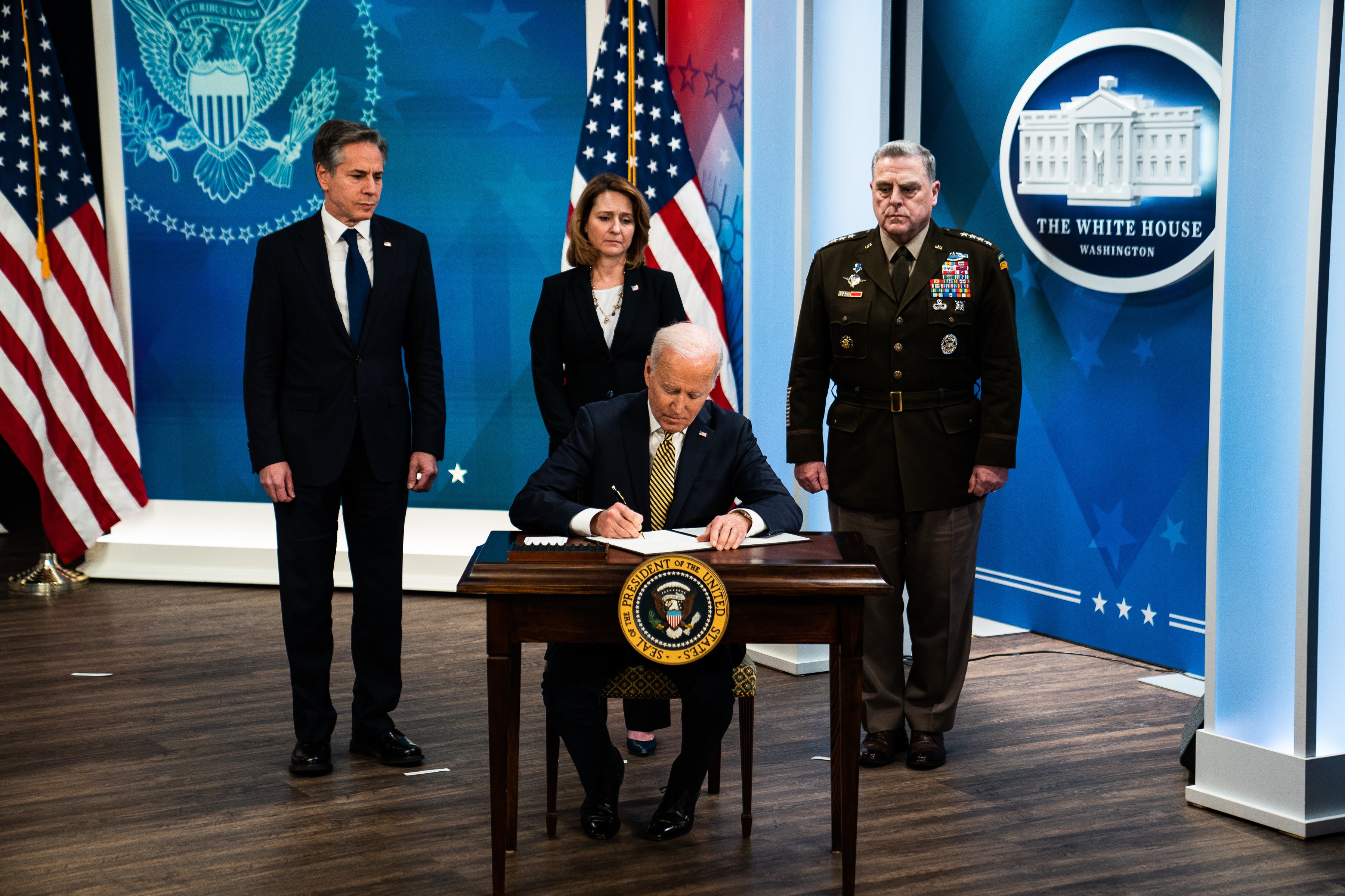 President Biden signs an economic aid package for Ukraine in March 2022 as Antony Blinken, Mark A Milley and deputy defence secretary Kathleen Hicks look on