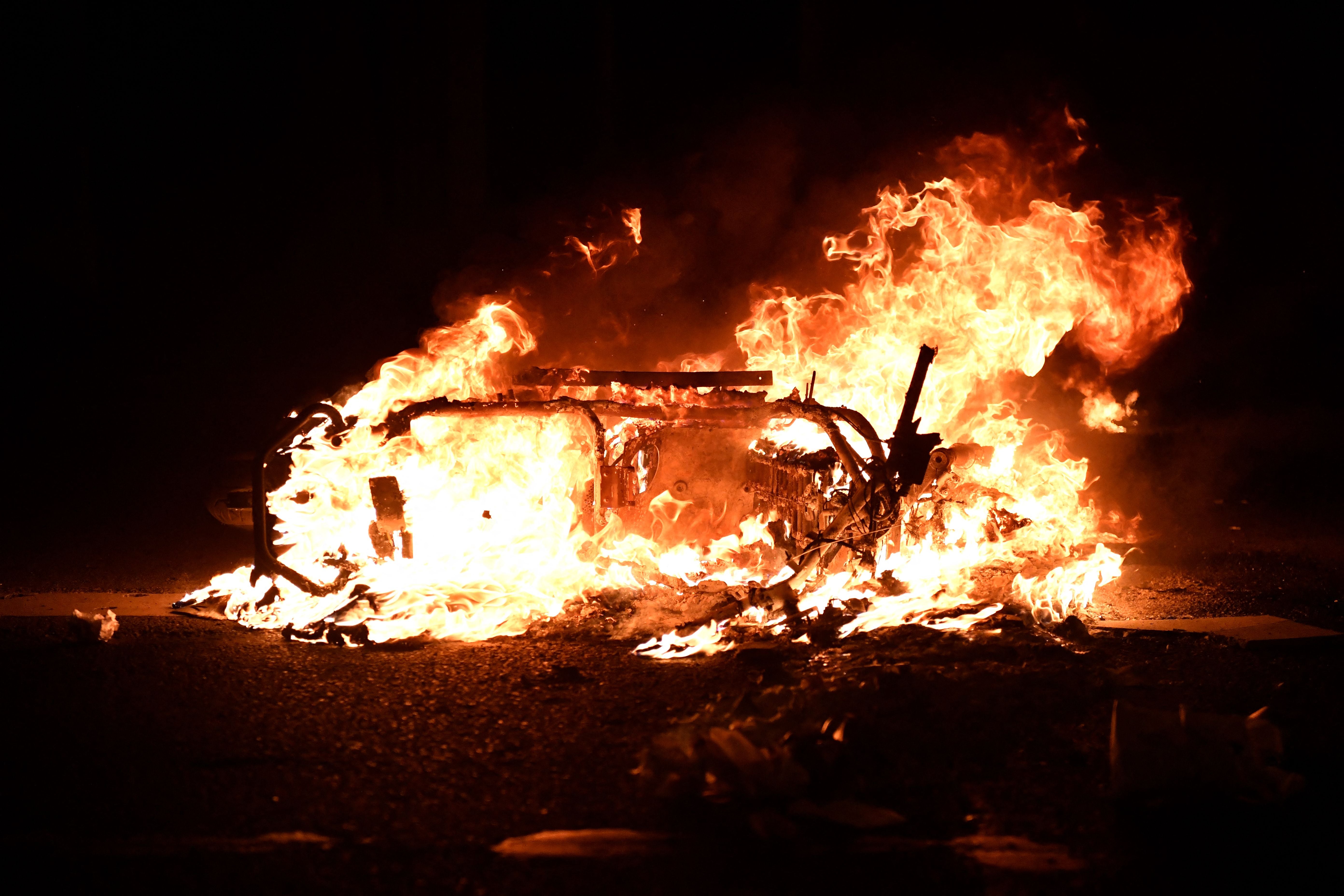 A scooter burns after being set alight by demonstrators