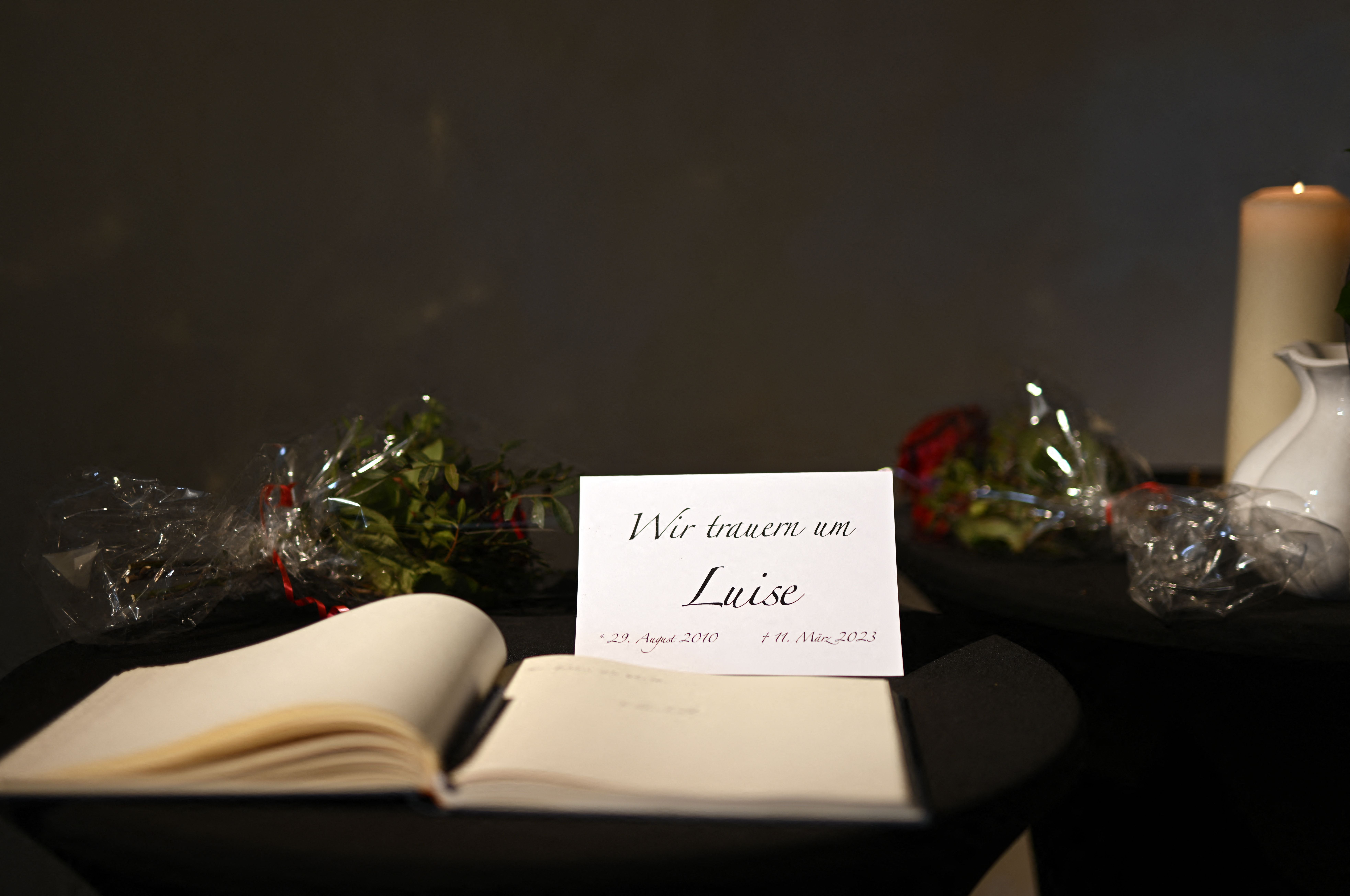 A book of condolences for the killed girl Luise and a card reading "We mourn Luise" are on display in the Protestant church in Freudenberg