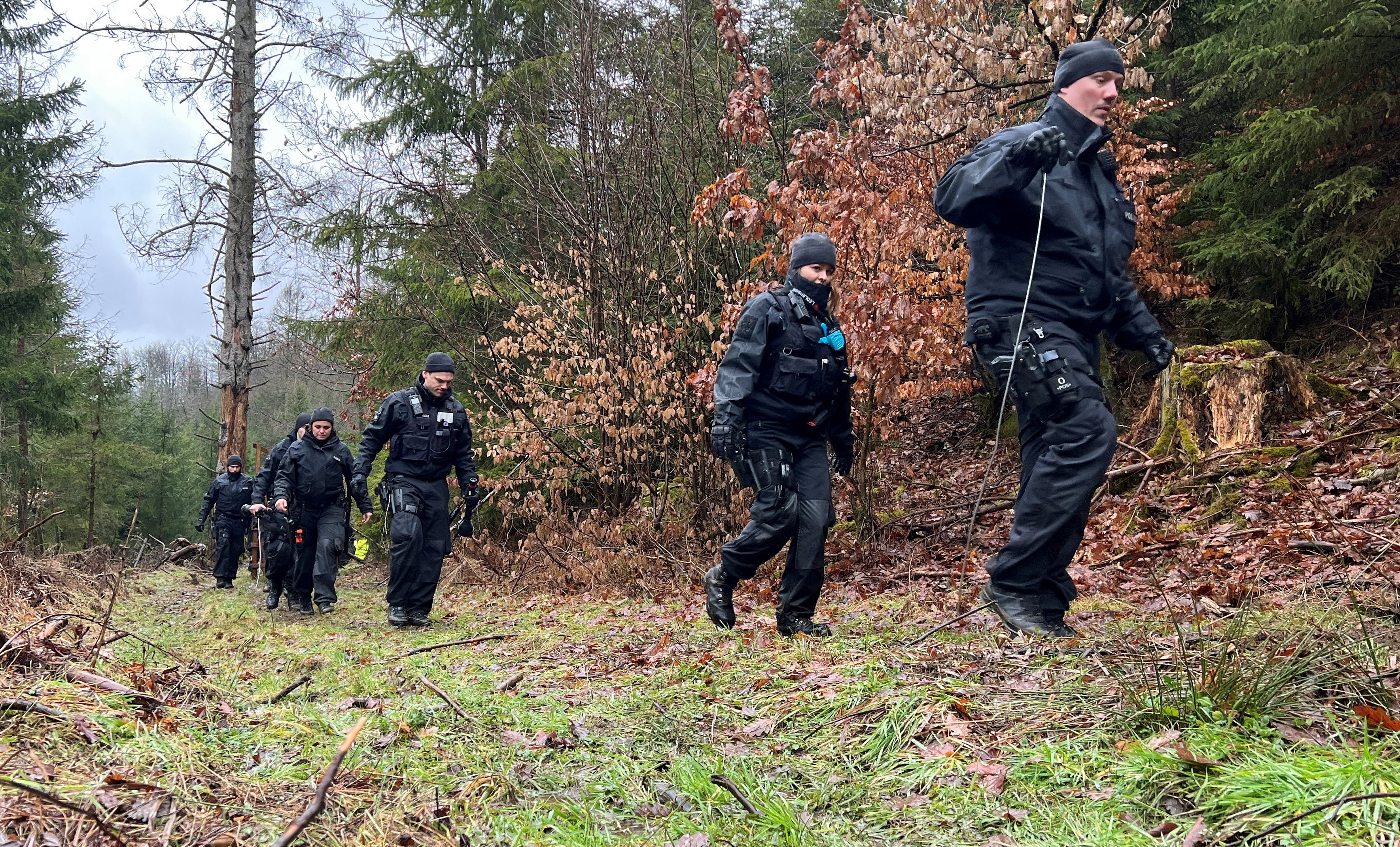 German police officer search for a knife in a woodland where the 12-year-old was found dead