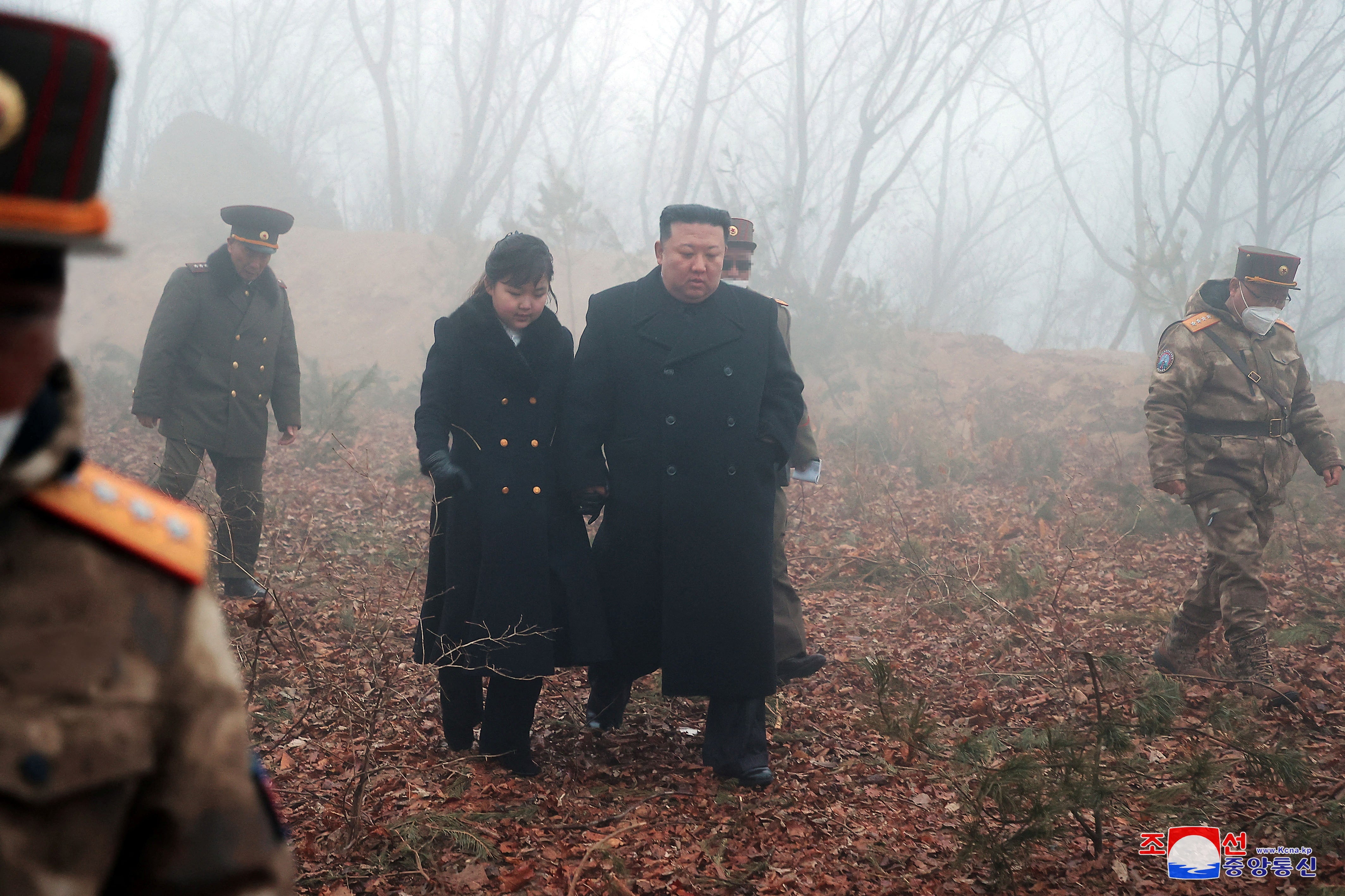 North Korean leader Kim Jong-un walks with his daughter Kim Ju-ae at an undisclosed location in this image released on 20 March