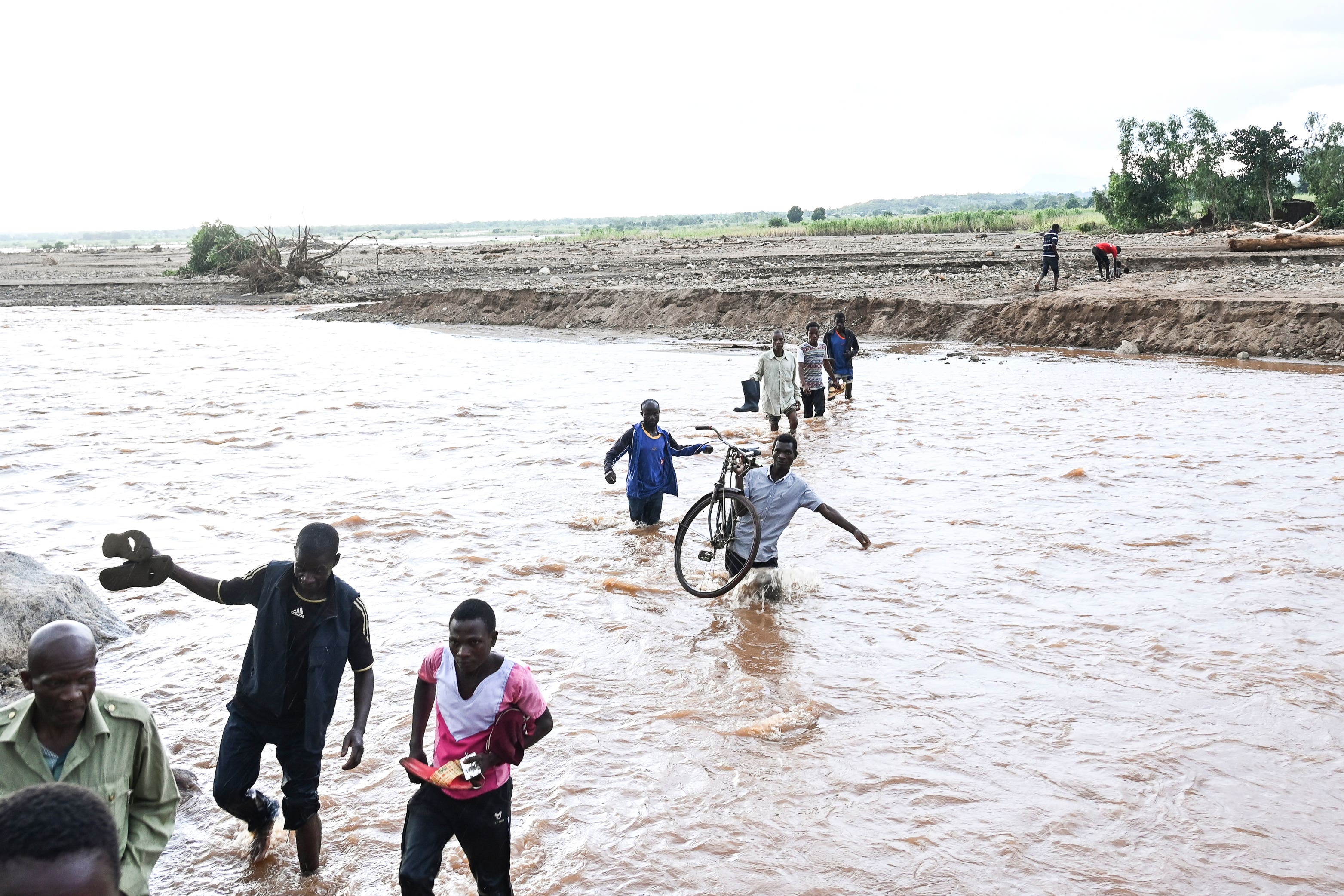 People wade through flood waters caused by last week’s heavy rains caused by Tropical Cyclone Freddy in Phalombe, southern Malawi on Saturday. Authorities are still getting to grips with destruction in Malawi and Mozambique with over 370 people confirmed dead and several hundreds still displaced or missing