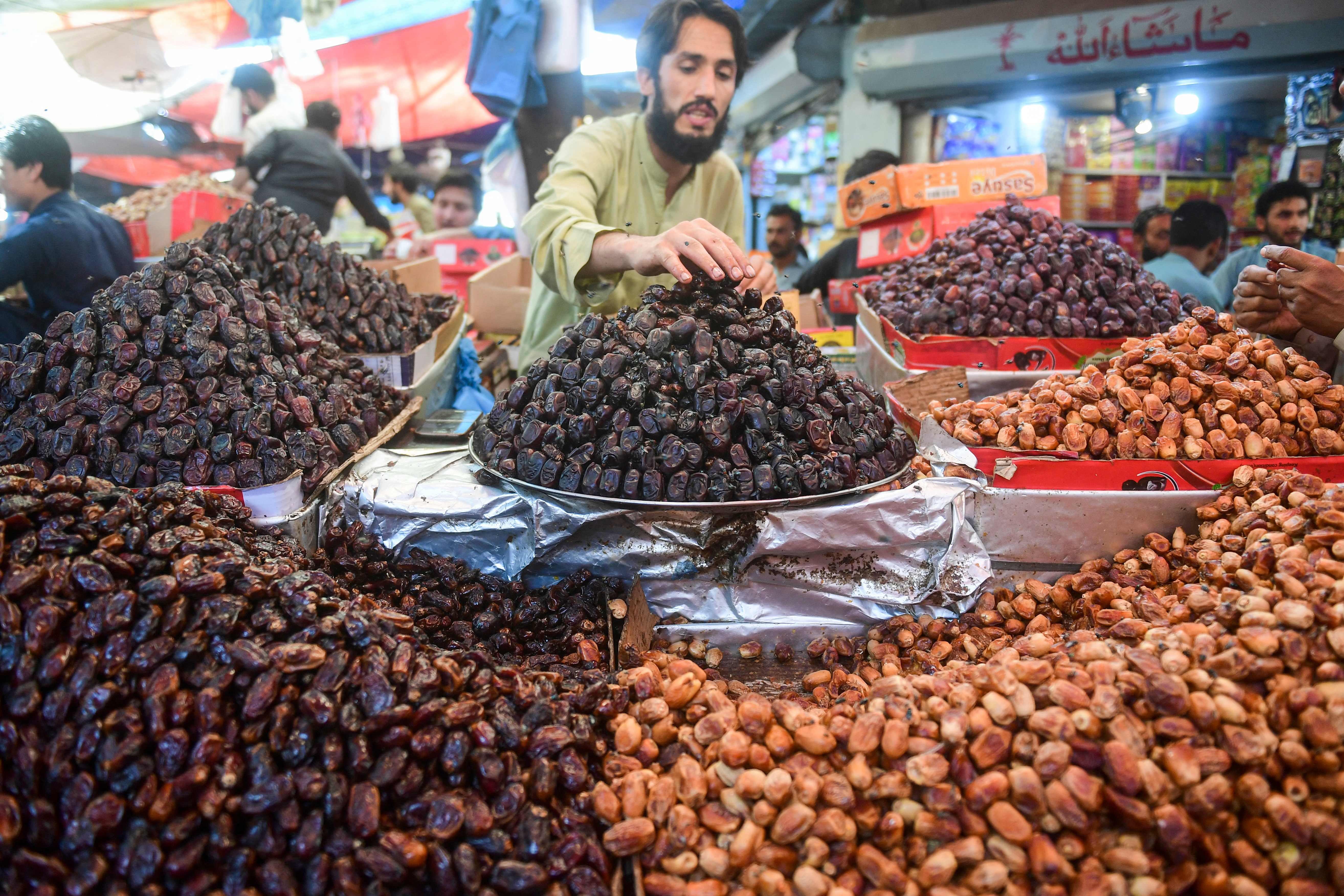 A vendor arranges dates at his stall in a market ahead of the Muslim holy fasting month of Ramadan in Karachi