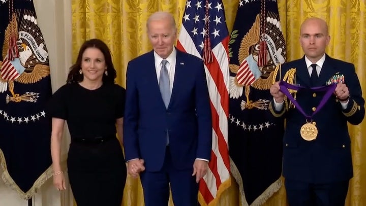Joe Biden holds hands with Julia Louis-Dreyfus as he presents her National Medal of Arts