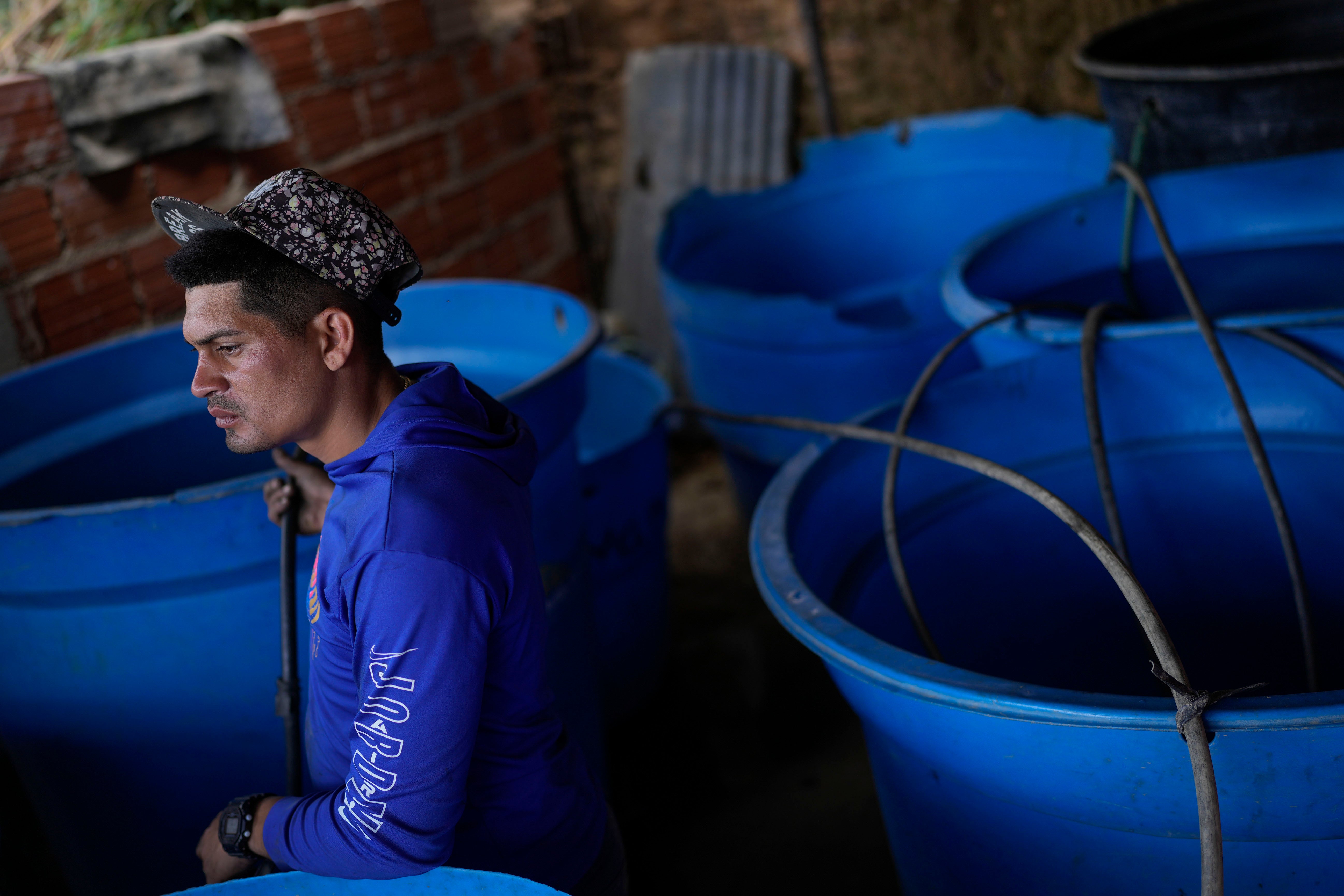 Franklin Caceres fills up tanks with water which it pumps from a groundwater well in the Petare neighborhood of Caracas, Venezuela on Monday. Caceres supplies water to more than 400 people in the upper sector of Petare