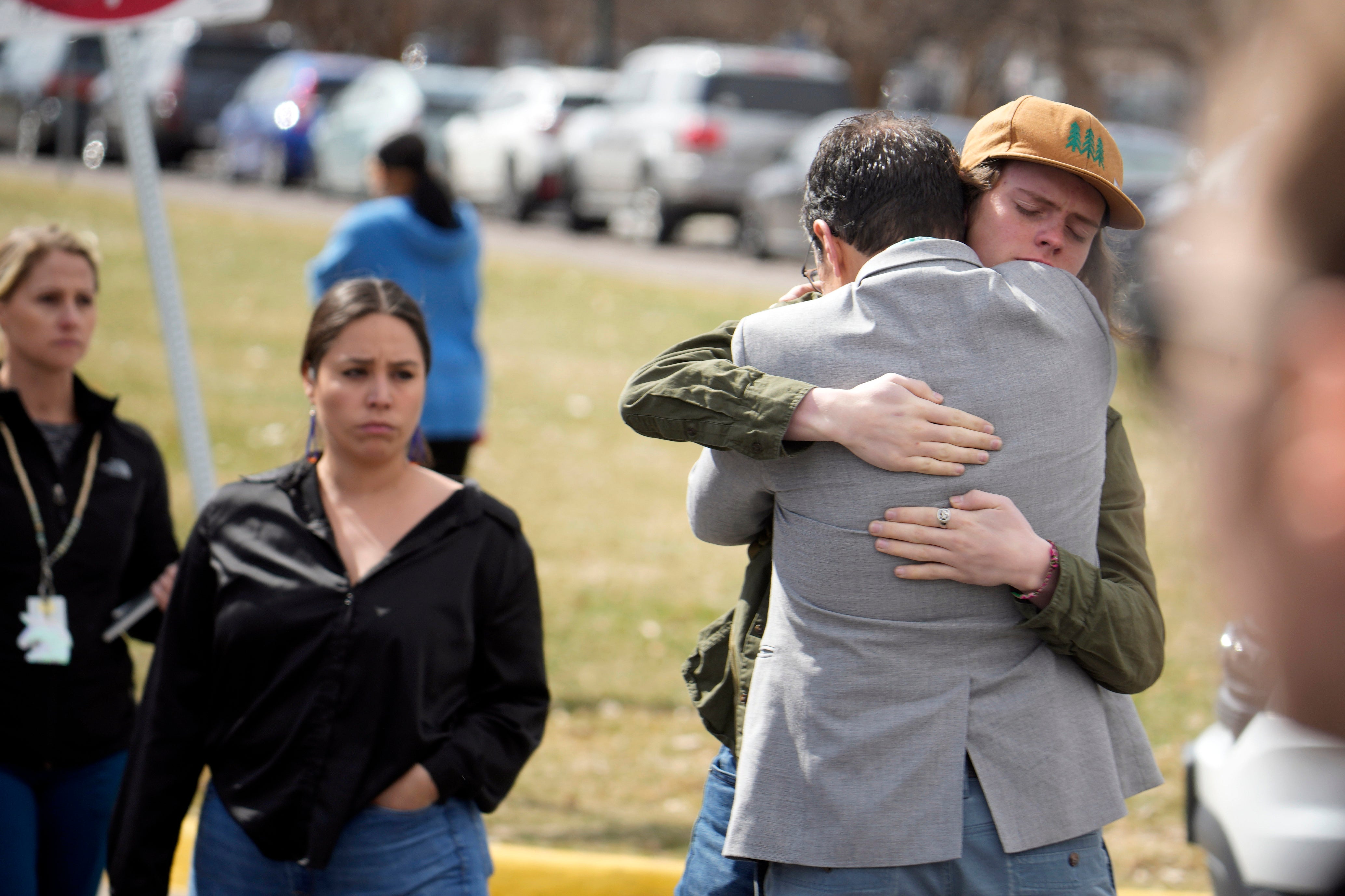 A student hugs a parent as they are reunited following a shooting at East High School