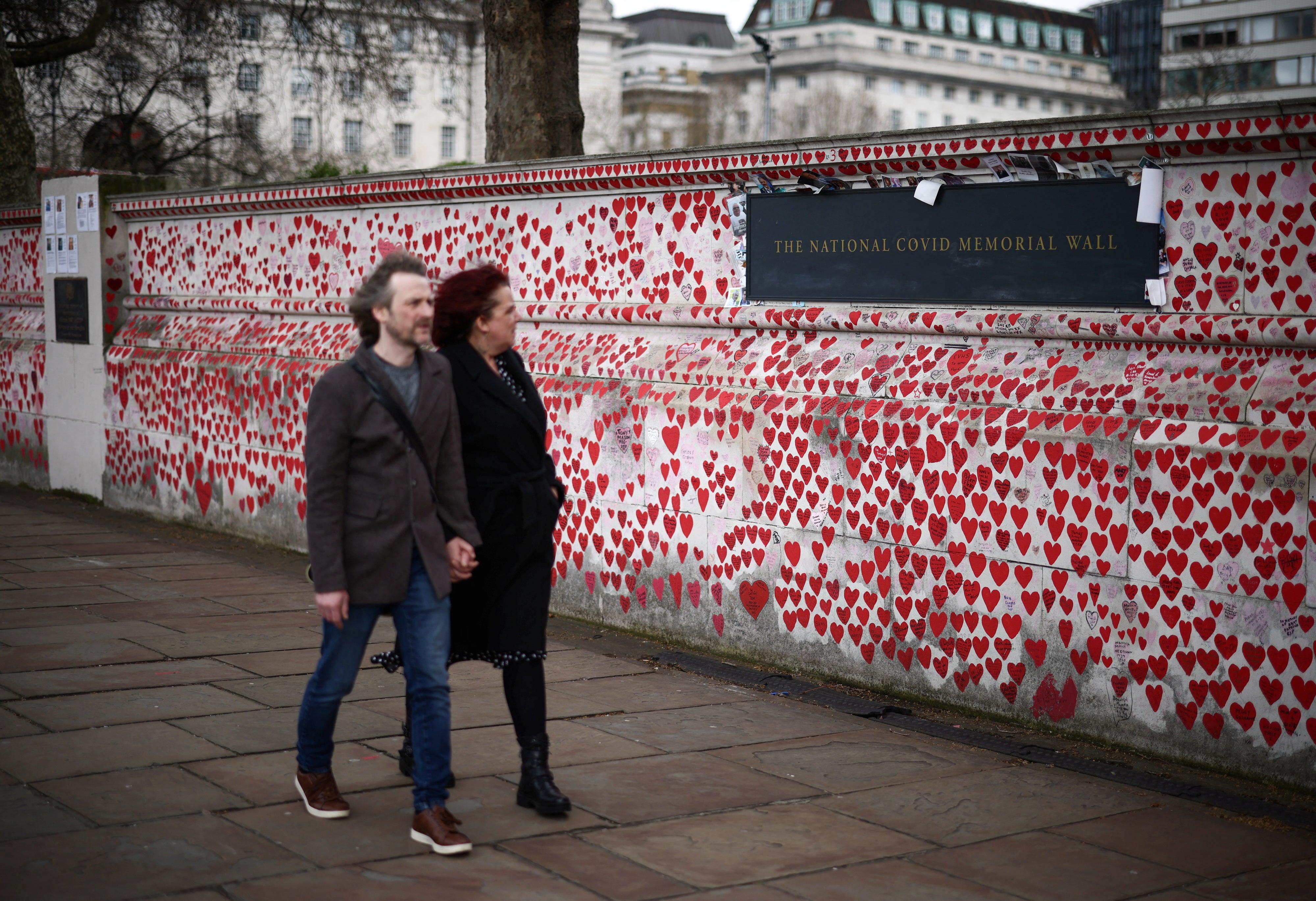 People walk past messages written on The National Covid Memorial Wall, on the third anniversary of the United Kingdom going into a national lockdown