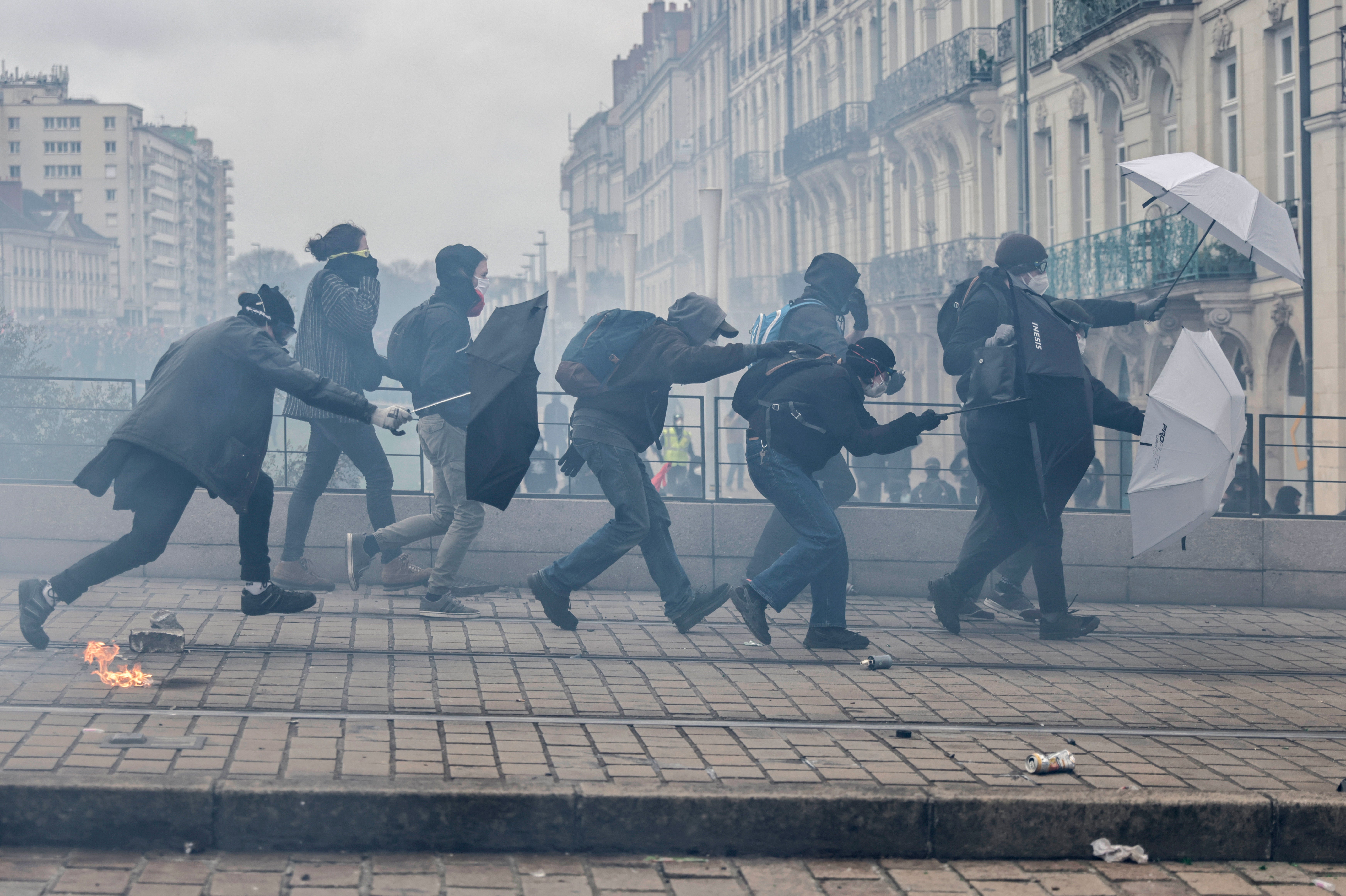 Protesters with umbrellas scuffle with riot police during a rally in Nantes on Thursday