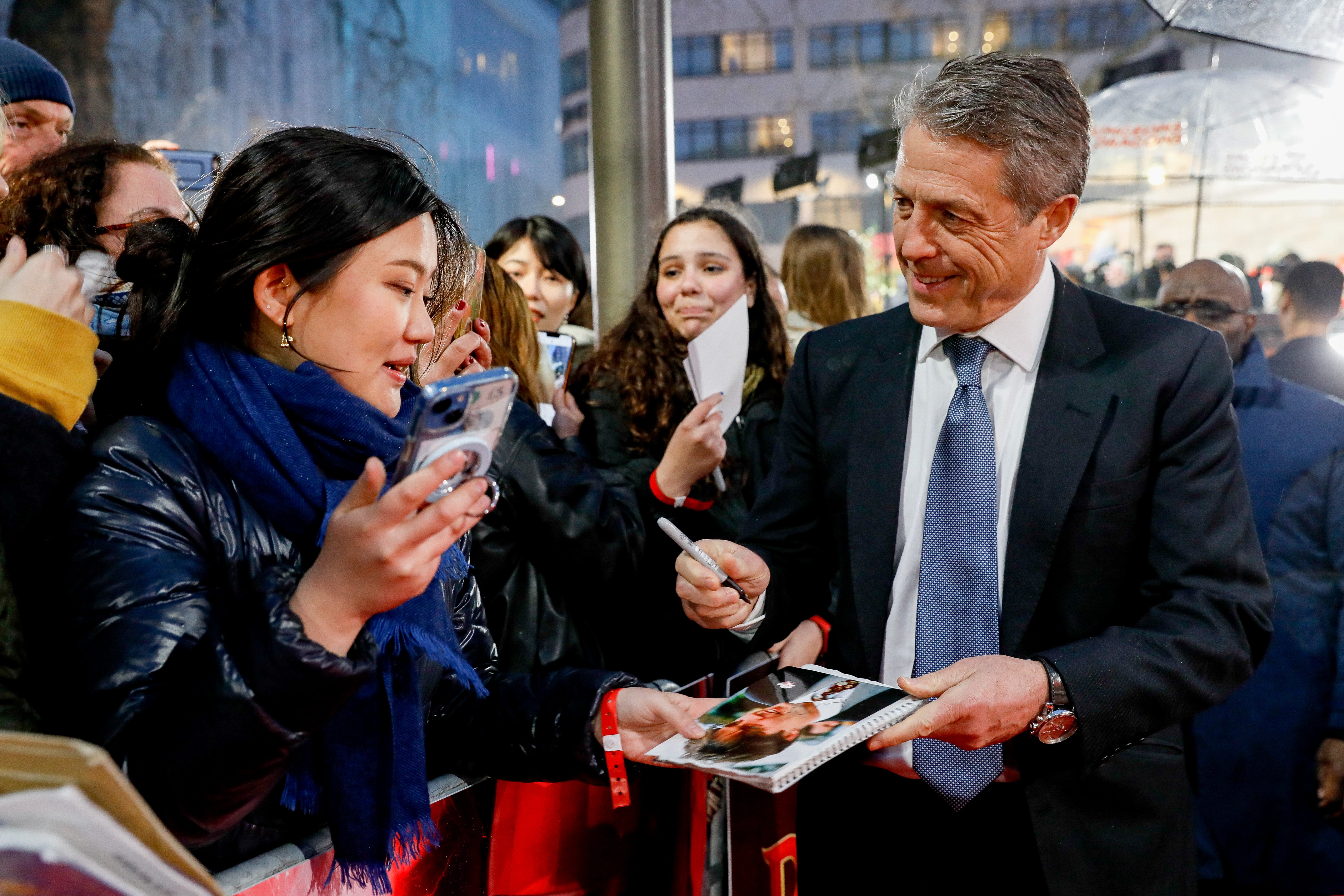 Grant singing autographs at the ‘D&D’ premiere