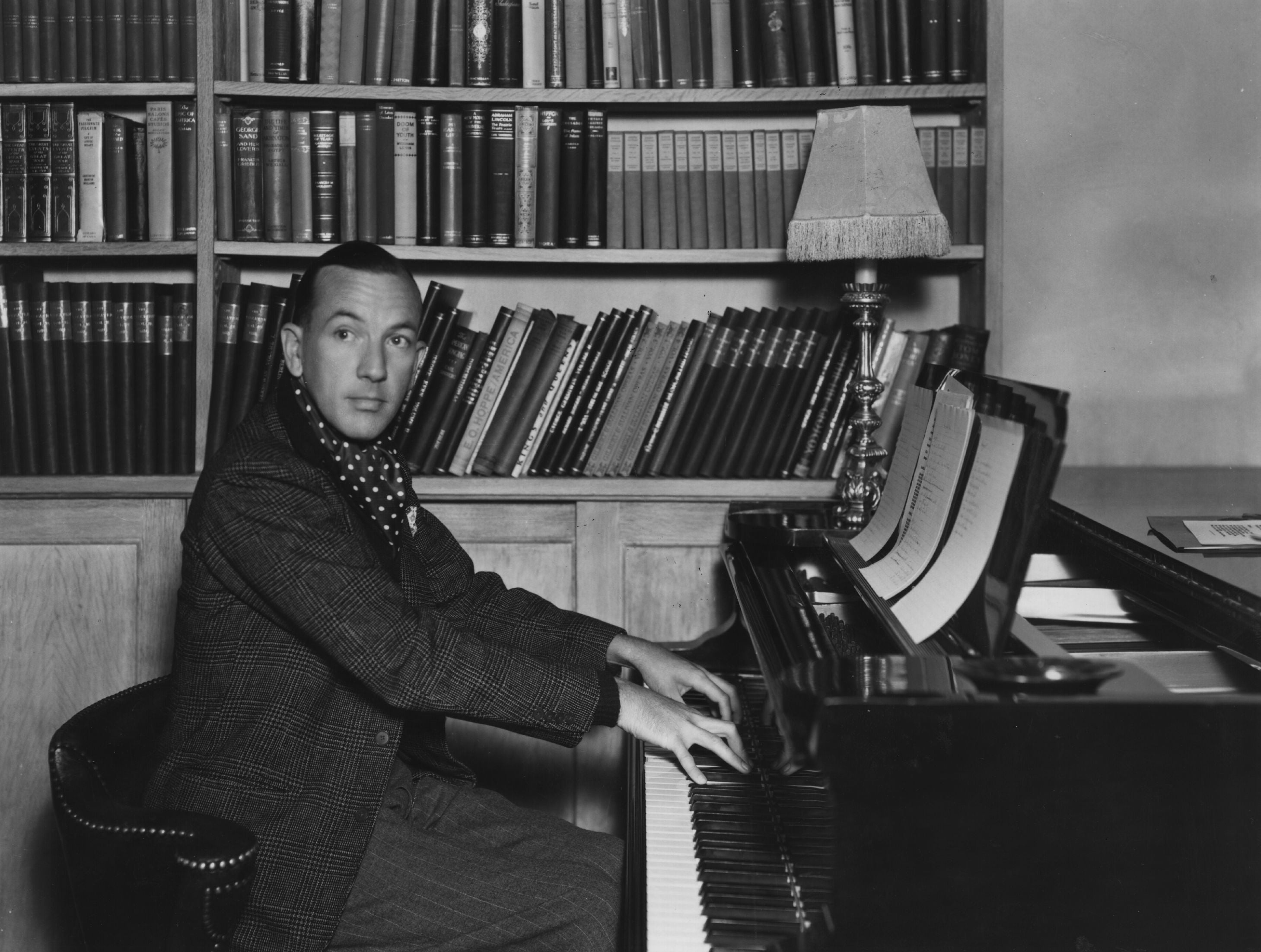 Coward, pictured playing the piano at home