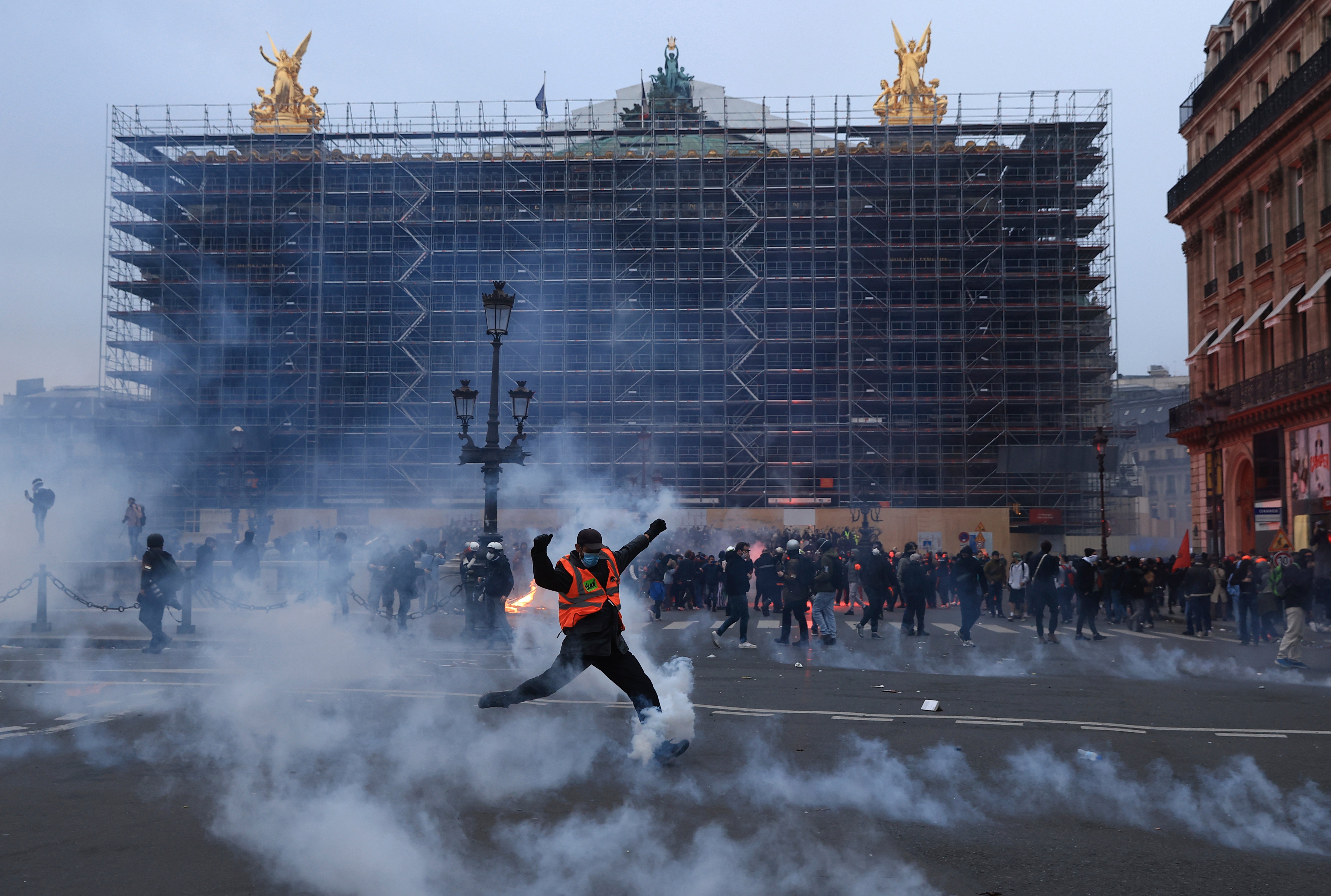 A protester kicks a tear gas canister in front of the Palais Garnier during Thursday’s protesters