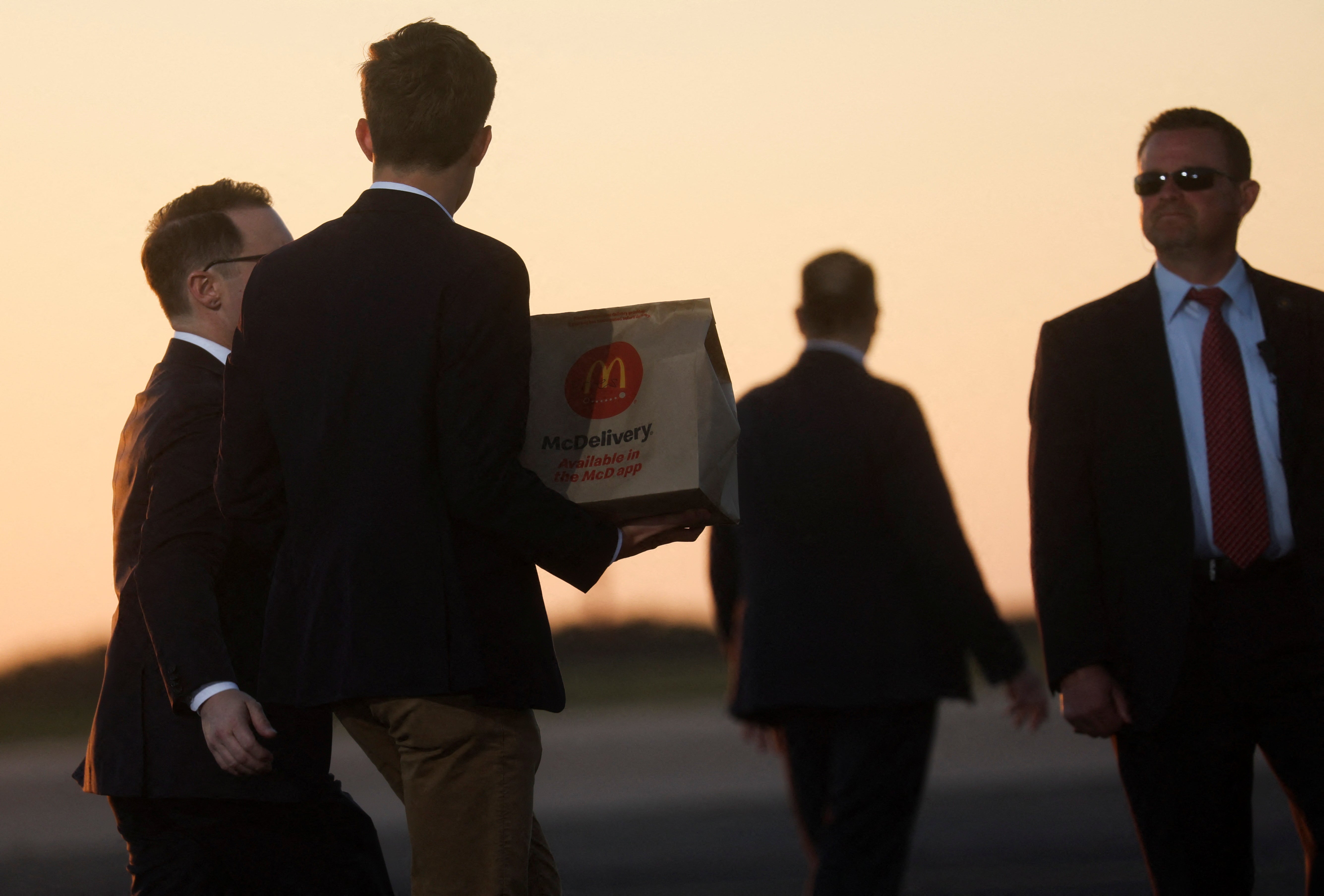 Staff carrying McDonald's on to the former president’s plane after rally