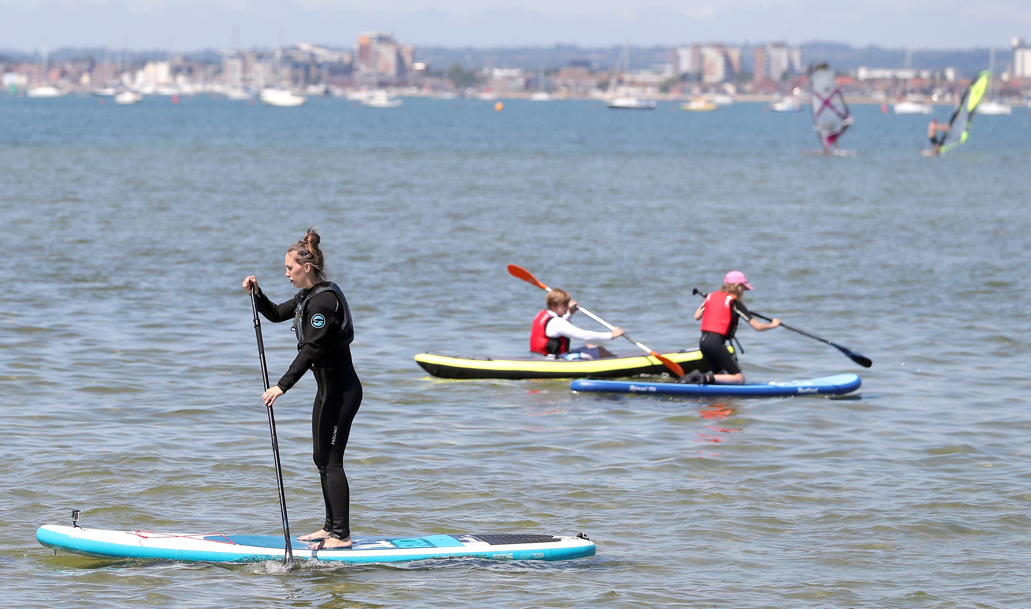 Paddle boarders enjoy warm weather in Poole Harbour in Dorset