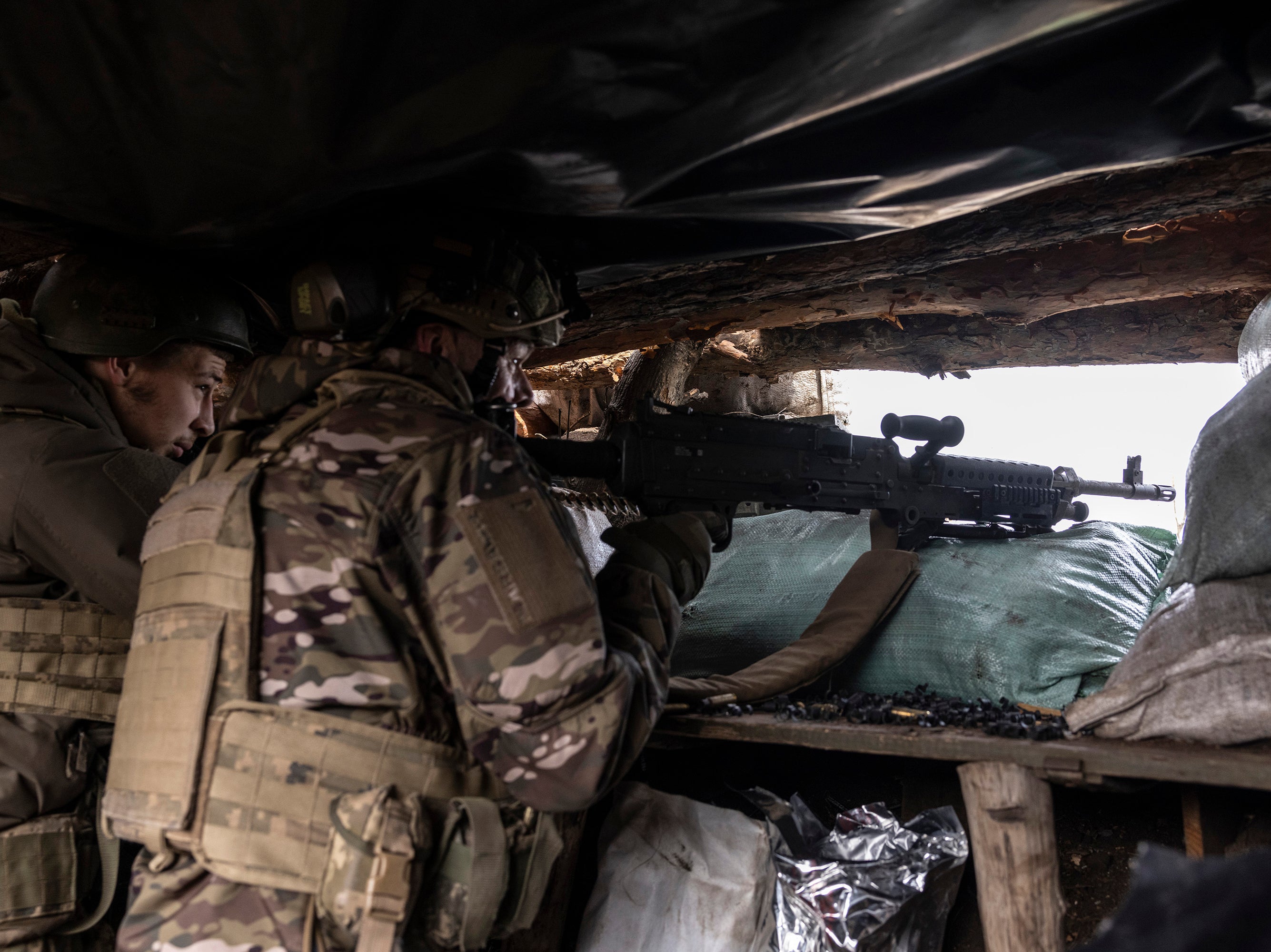 Ukrainian soldiers from the 24th Separate Mechanised Brigade use a US-made M240 machine gun to shoot towards Russian positions