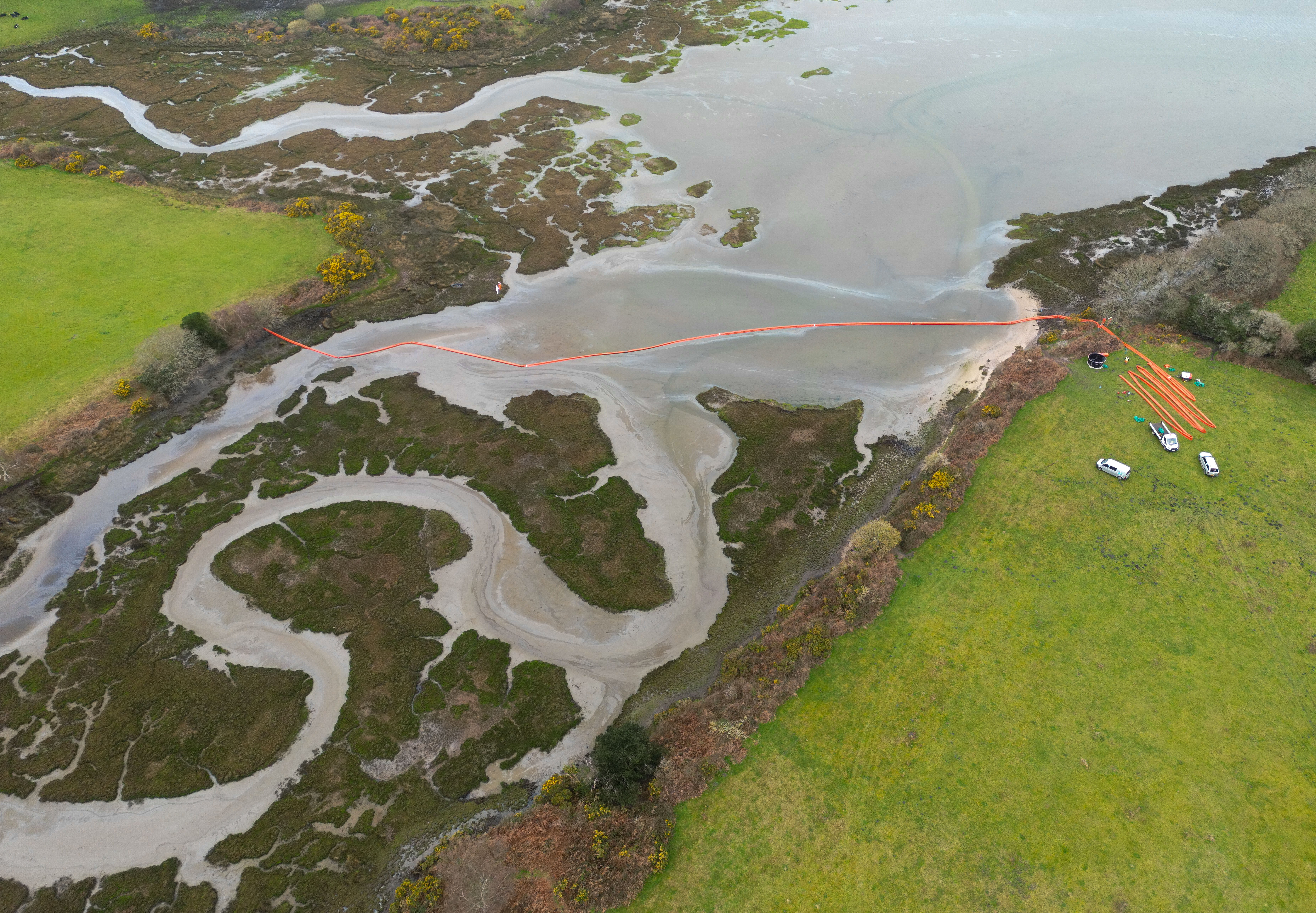 Workers have placed a boom across the water at Owers Bay in Poole harbour