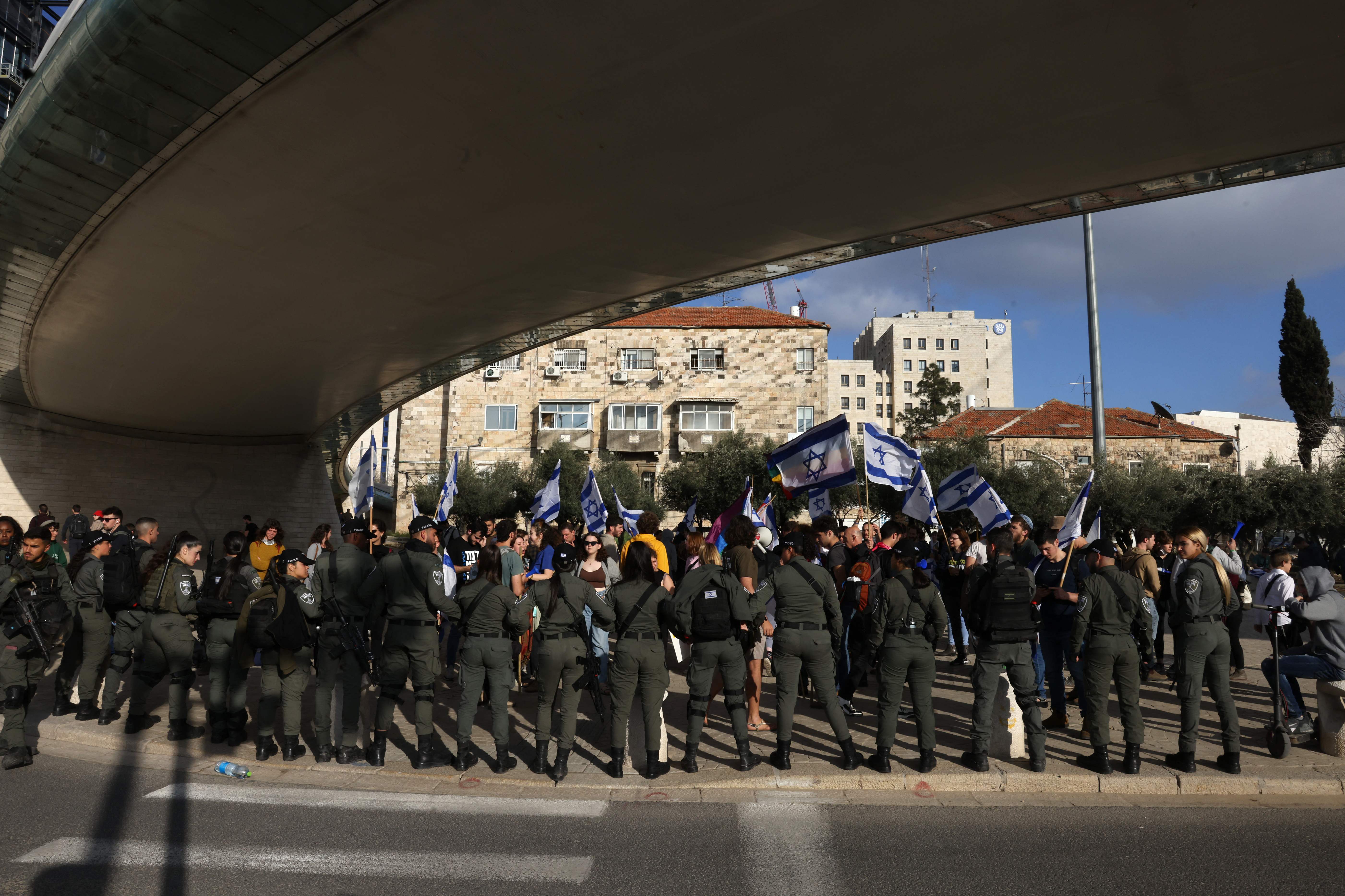 Israeli police stand guard as protesters gather outside Israel's parliament in Jerusalem