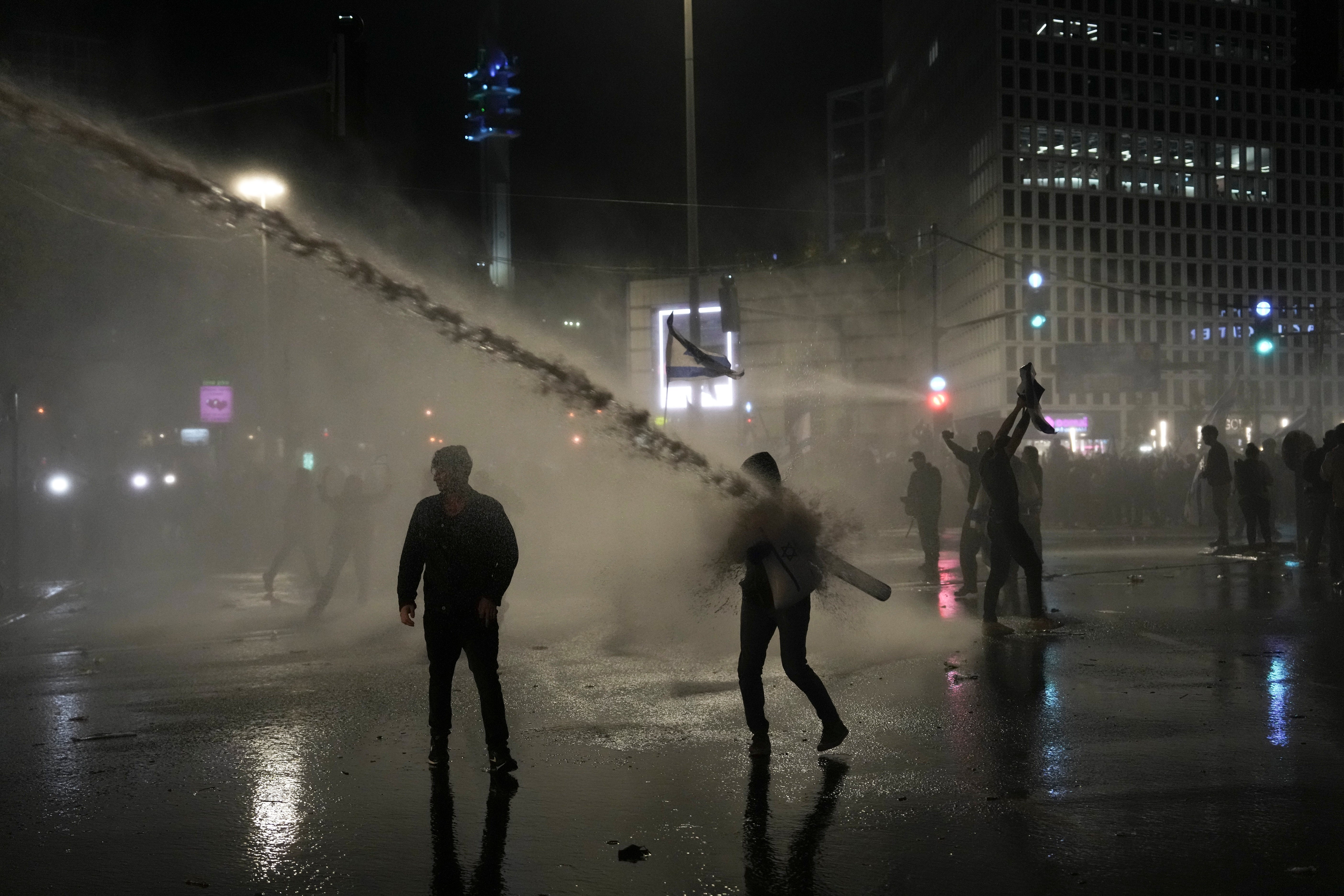 Israeli security forces use water canons to disperse protesters during ongoing demonstrations in Tel Aviv on March 27, 2023.