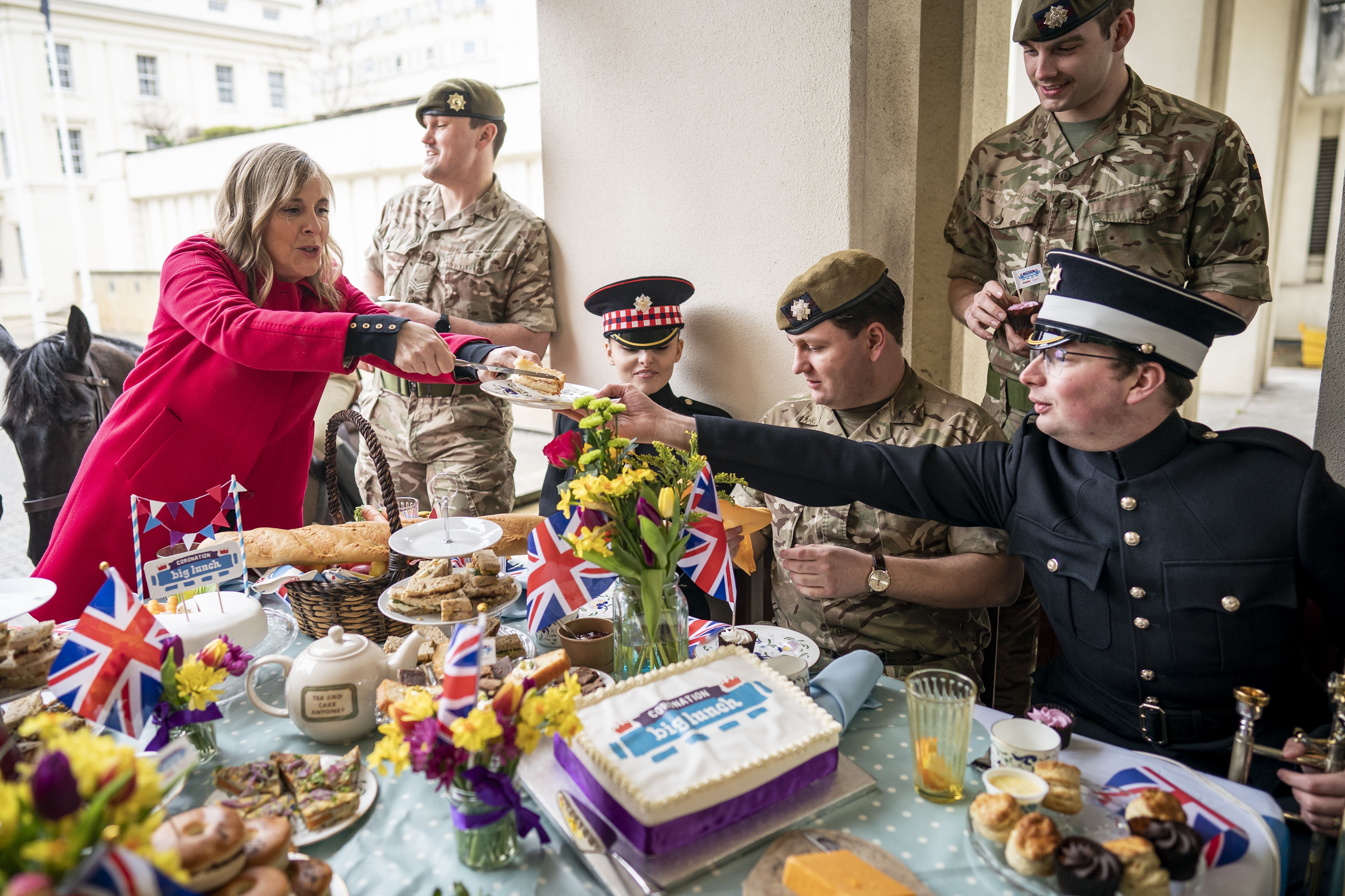 Presenter Mel Geidroyc with members of the Scots Guards and Coldstream Guards during the Coronation Big Lunch with military at Wellington Barracks, London (Aaron Chown/PA)