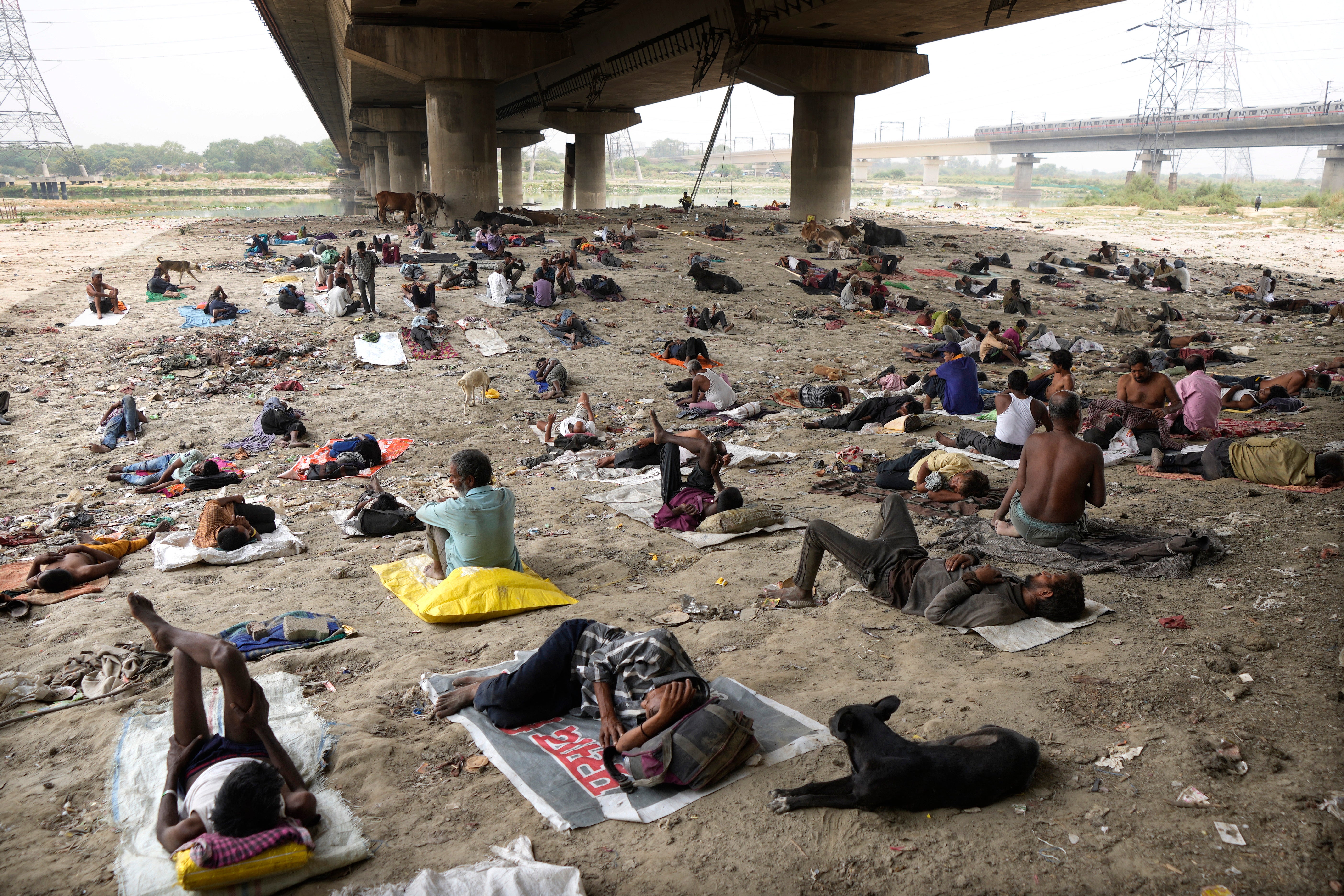 Homeless people sleep in the shade of an overpass to beat the heatwave in New Delhi, India