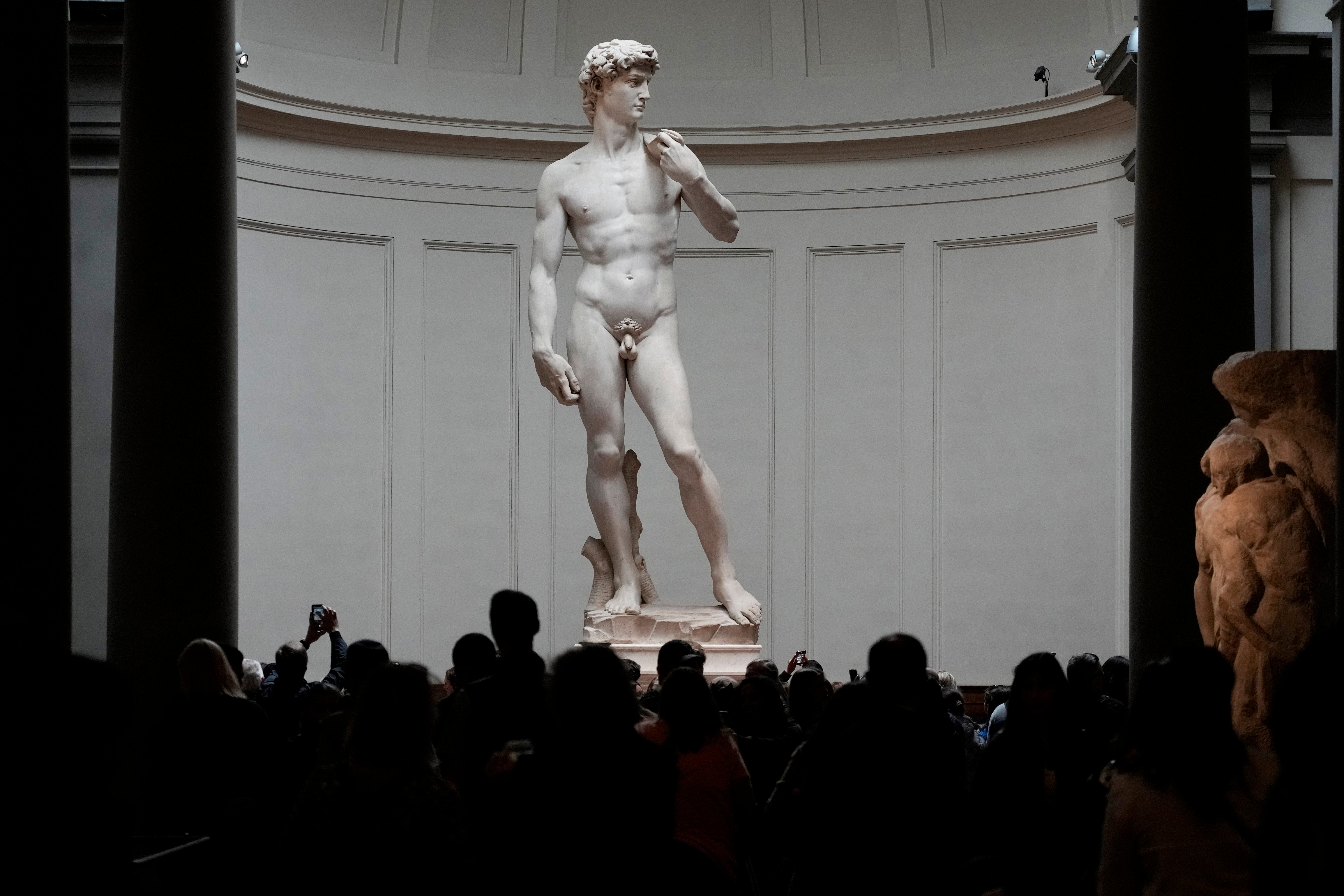 Visitors stand in front of Michelangelo’s David statue in the Accademia Gallery in Florence, Italy