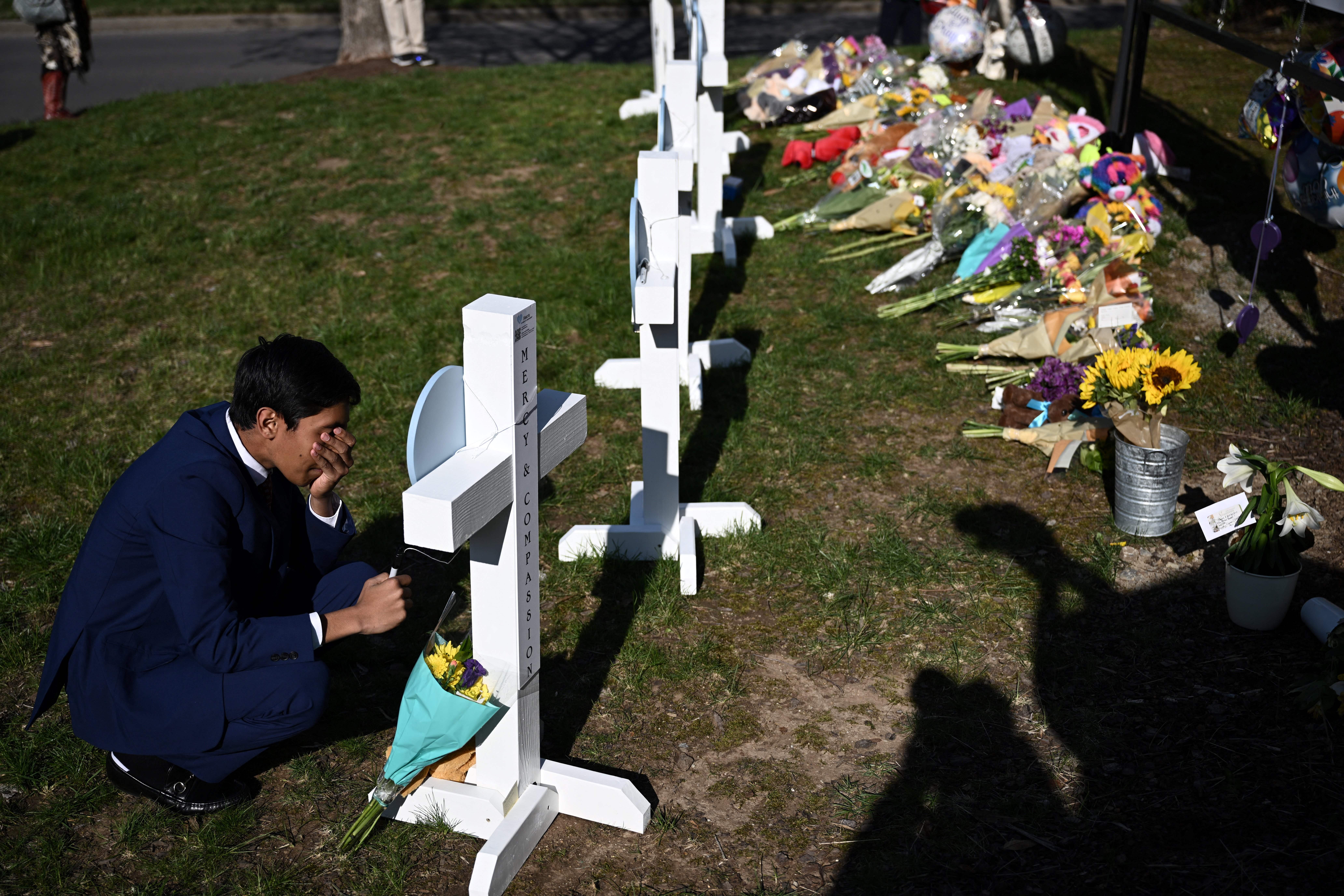 People pay their respects at a makeshift memorial for victims at the Covenant School building at the Covenant Presbyterian Church