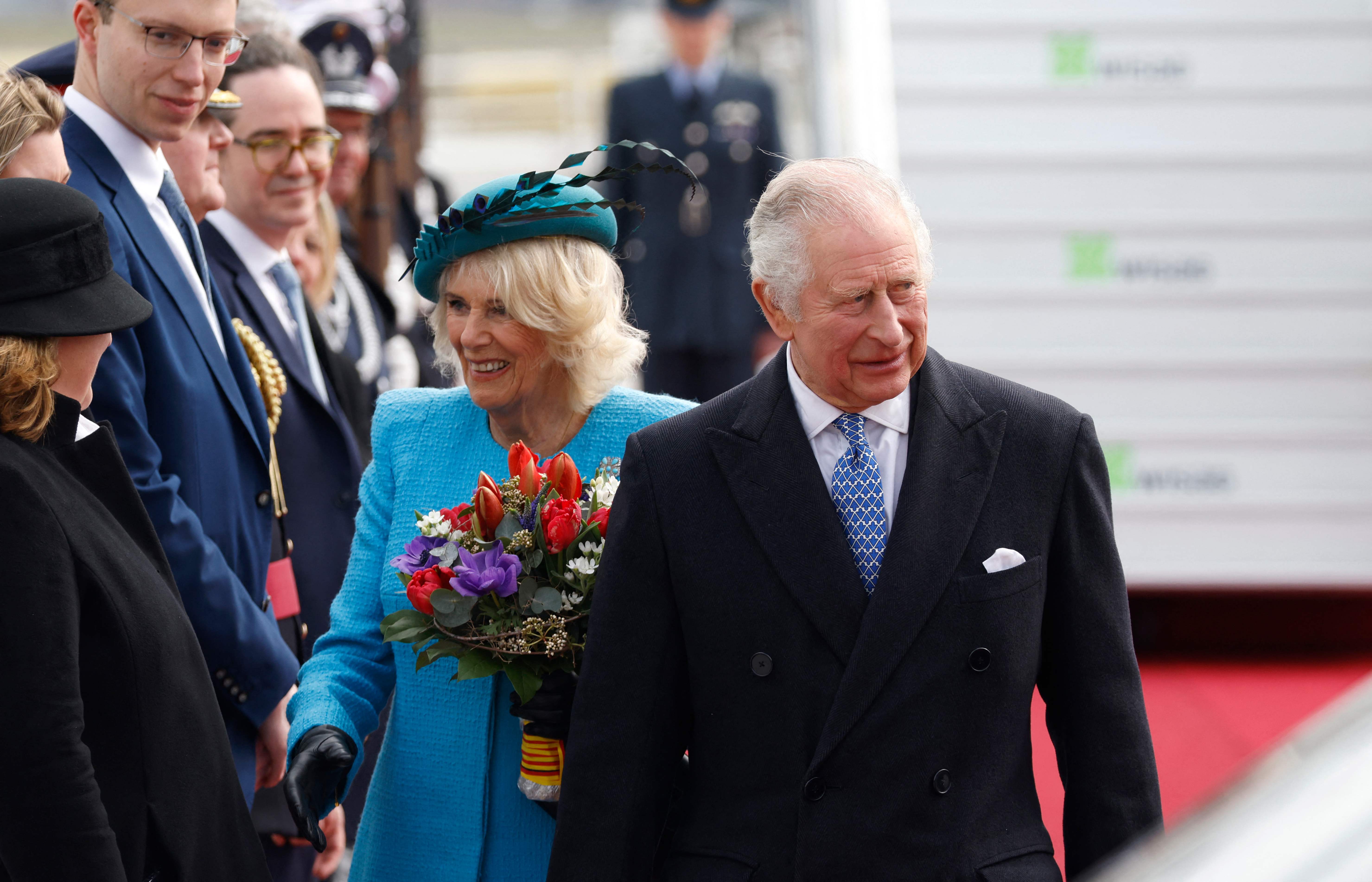 Charles and Camilla arrive at the airport and greet Royalists