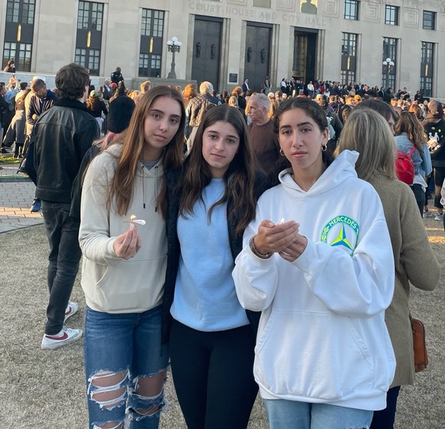 Vanderbilt University students (l-r) Kathleen Praino, Chloe Berg and Sophia Pieri hold candles at the Wednesday vigil, also attended by first lady Dr Jill Biden