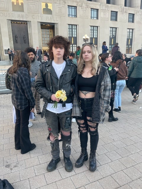 Willis Egan, 15, holds flowers that he brought to the vigil with his older sister, El, 23 – one flower for each victim killed on Monday, picked from their mother’s garden