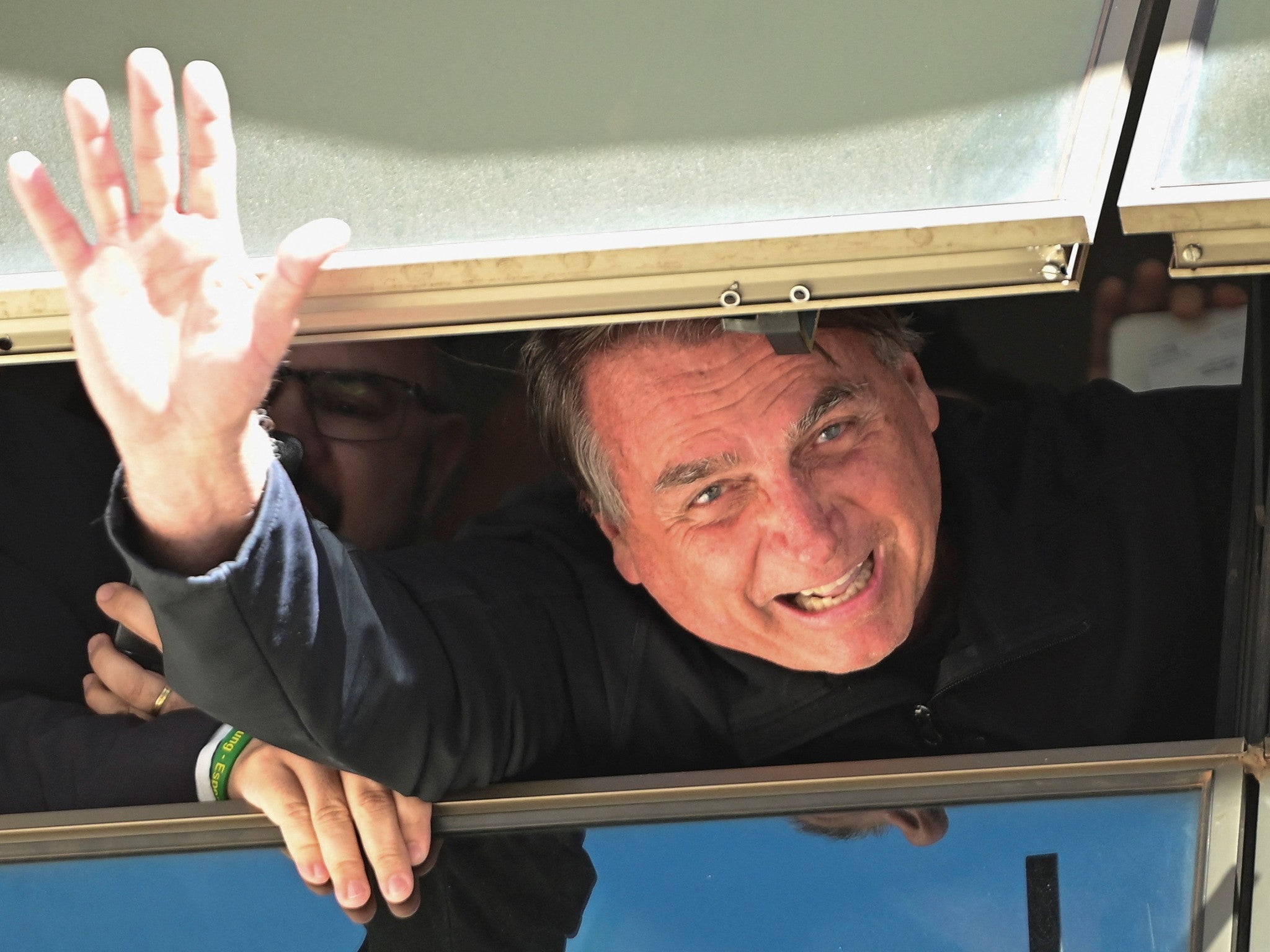 Jair Bolsonaro waves to supporters at Brasilia International Airport