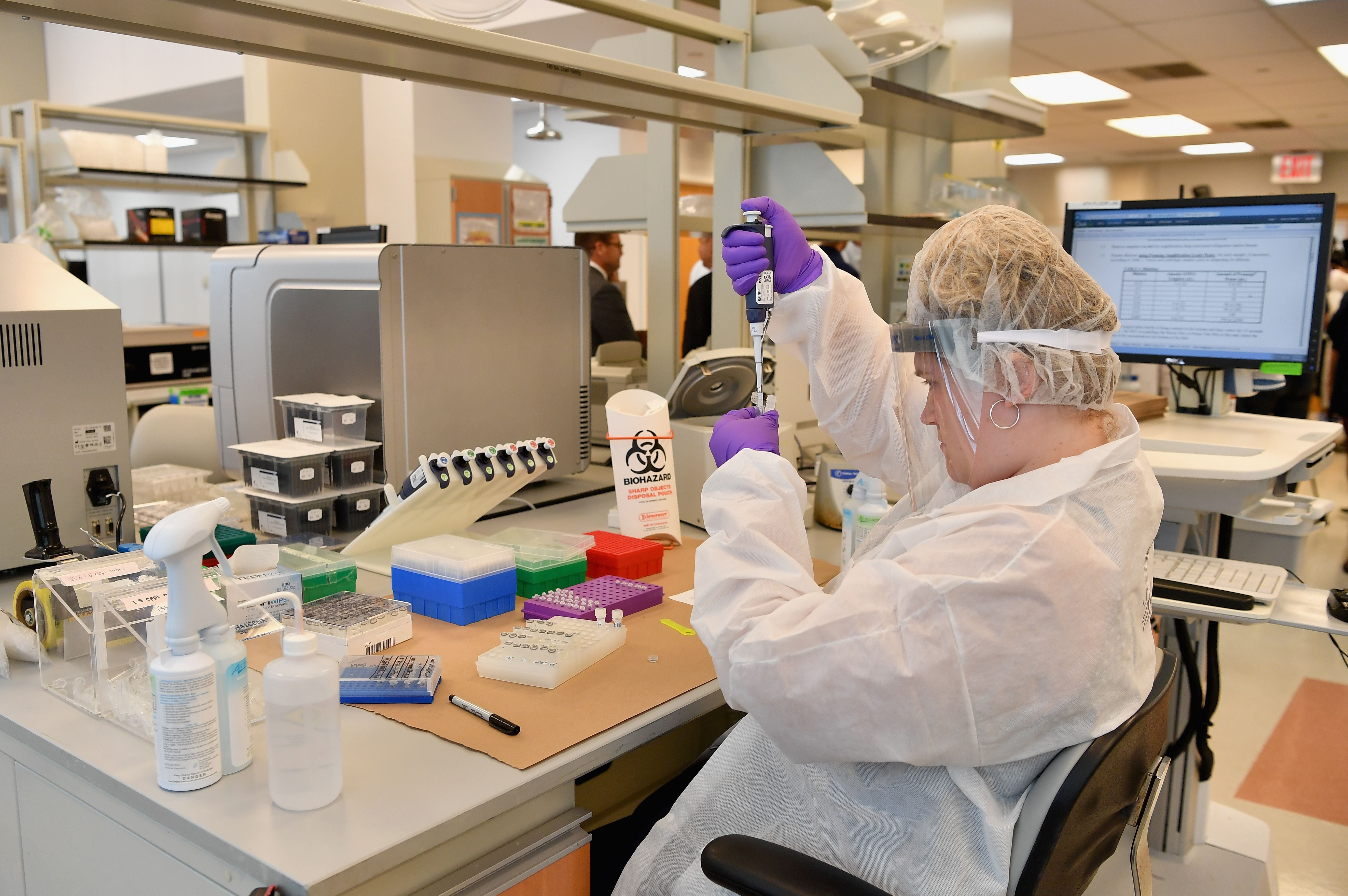 A lab worker transfers solutions from one tube to another at the New York City Office of Chief Medical Examiner