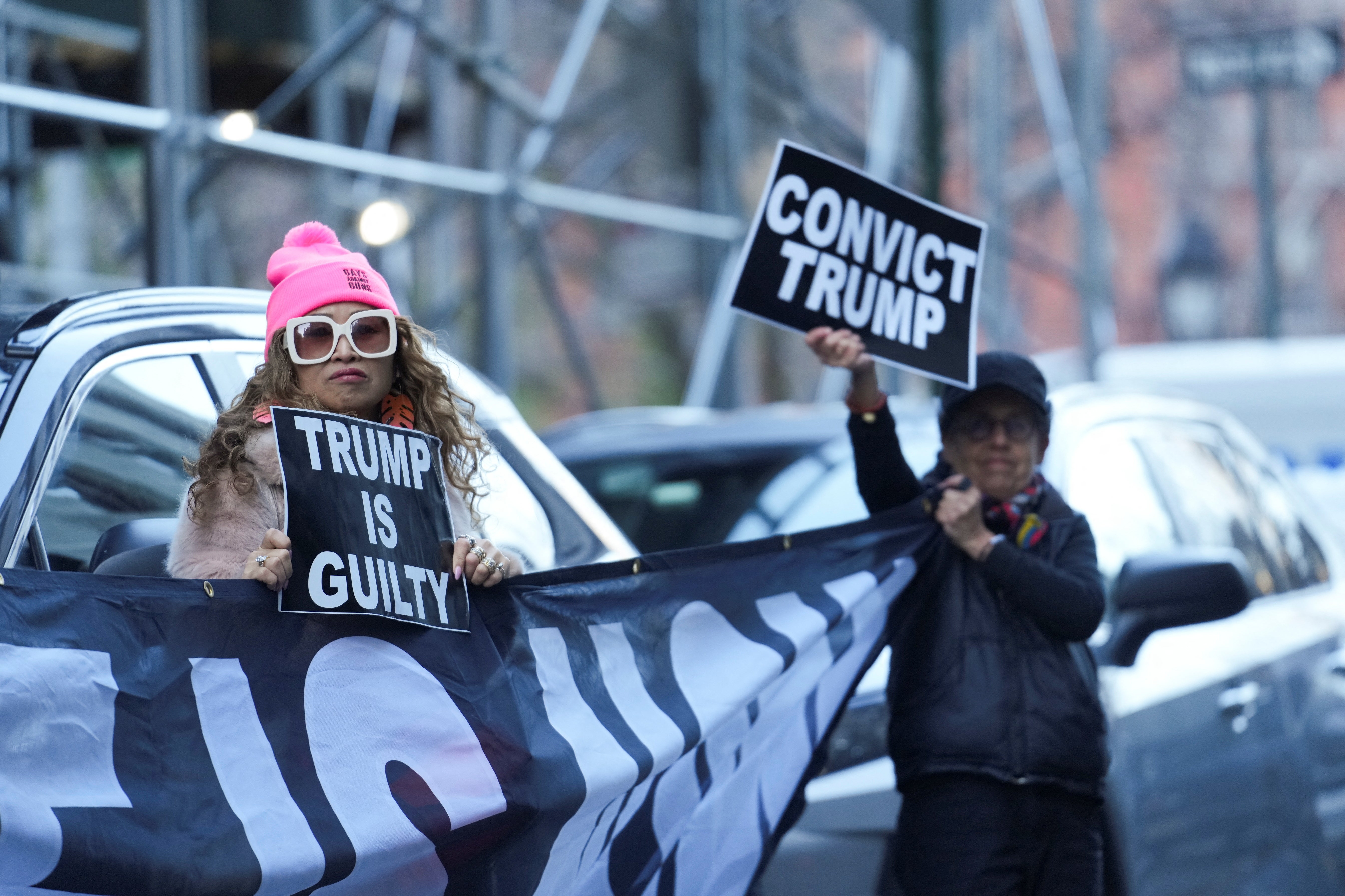 Anti-Trump protesters hold signs outside Manhattan Criminal Court after Donald Trump’s indictment