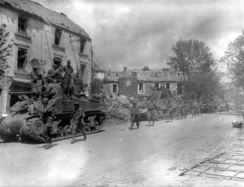 American armoured and infantry forces pass through the Normandy town of Coutances during Operation Cobra